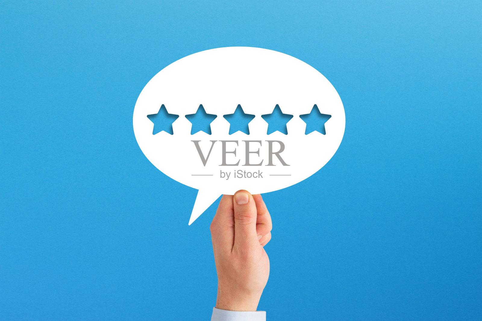最好的评级。在蓝色背景的语音气泡中,手握五星形状。照片摄影图片