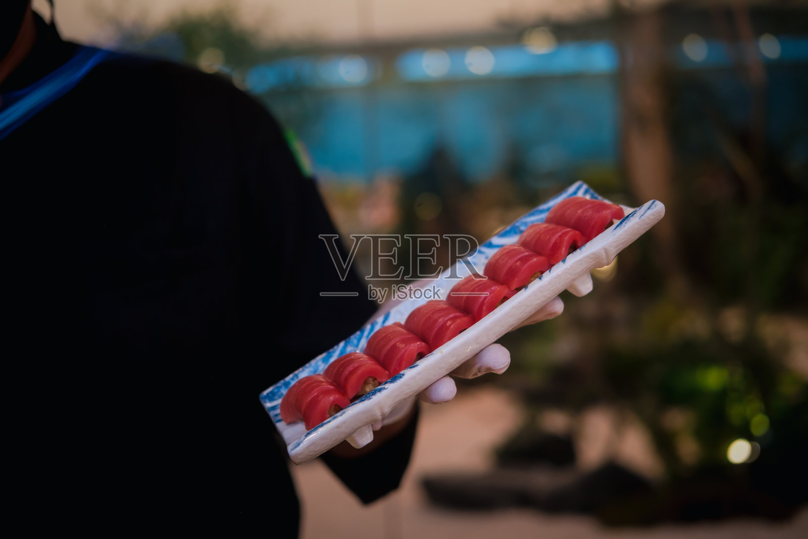 专业寿司师傅拿着寿司盘。照片摄影图片