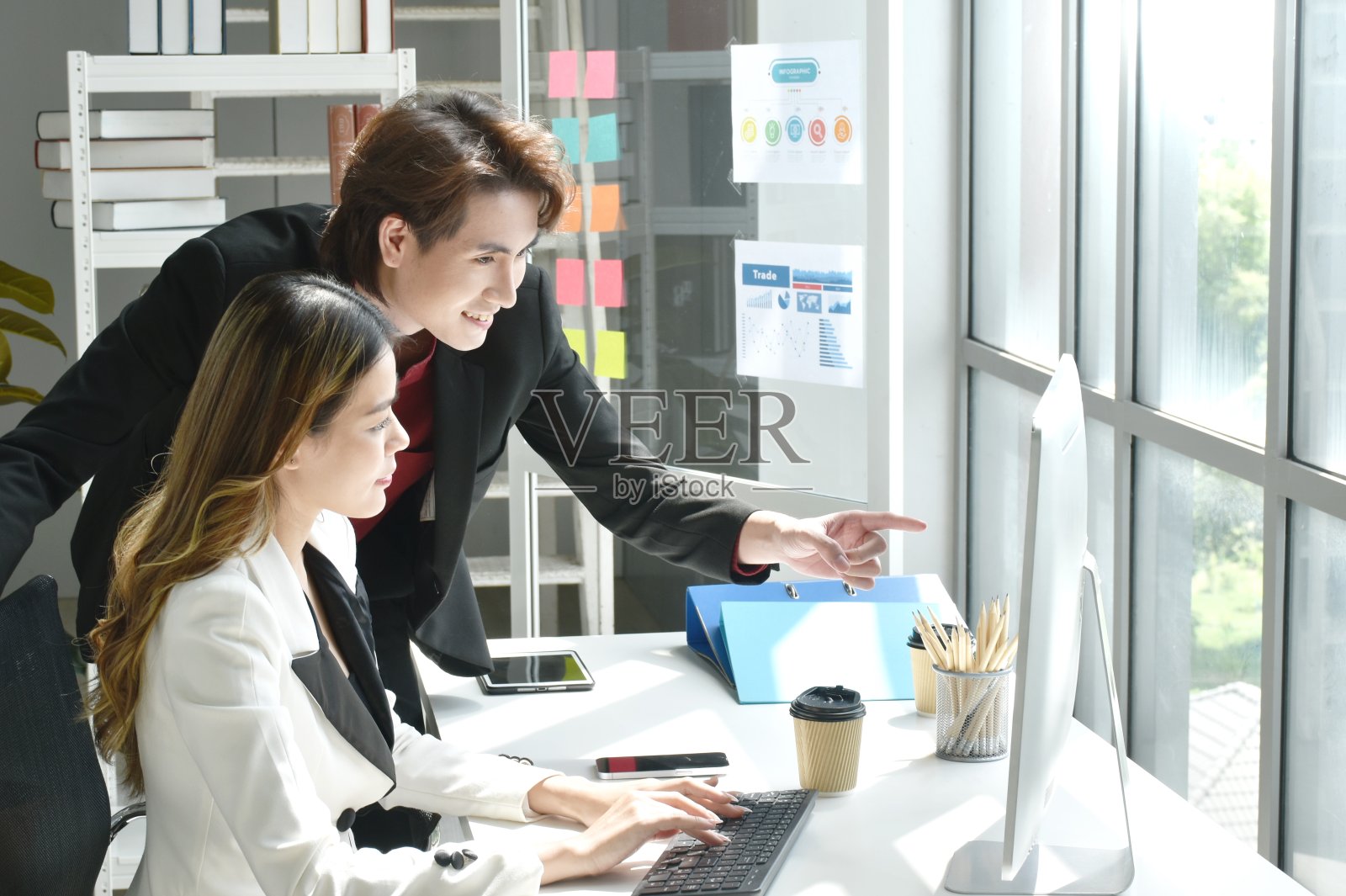 亚洲商人男女看着笔记本电脑屏幕讨论和工作照片摄影图片