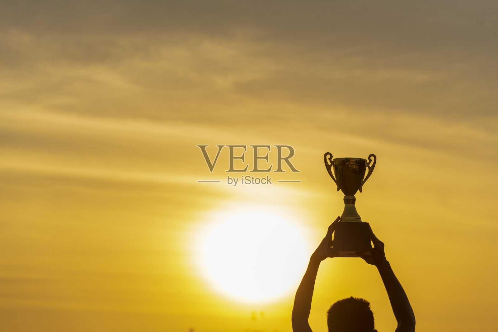 优胜者手握金冠奖杯杯奖。剪影最佳奖胜利手捧奖杯职业冠军挑战队捧金质体育奖杯杯。双赢运动团队理念照片摄影图片