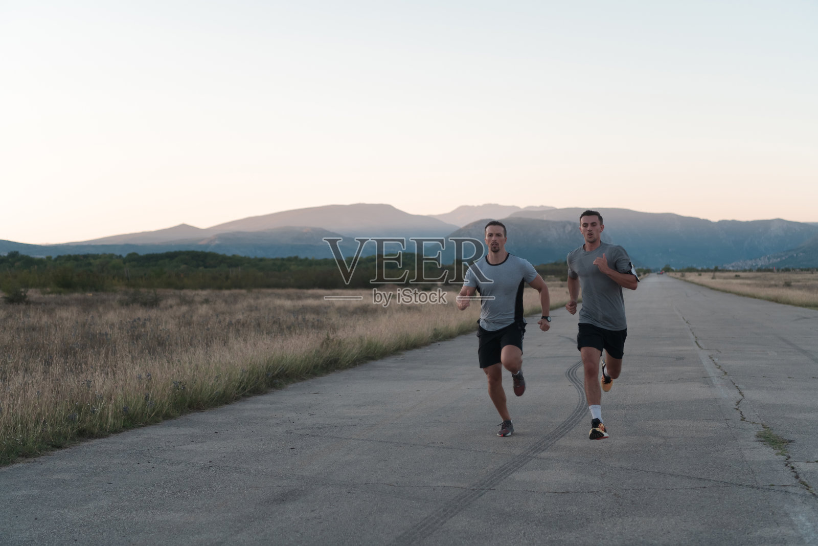 一群热爱运动的年轻人在一个阳光明媚的早晨在城市里慢跑。照片摄影图片