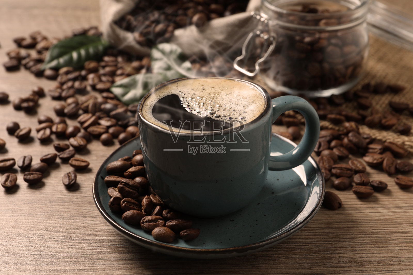 一杯芳香的热咖啡和豆子放在木桌上照片摄影图片