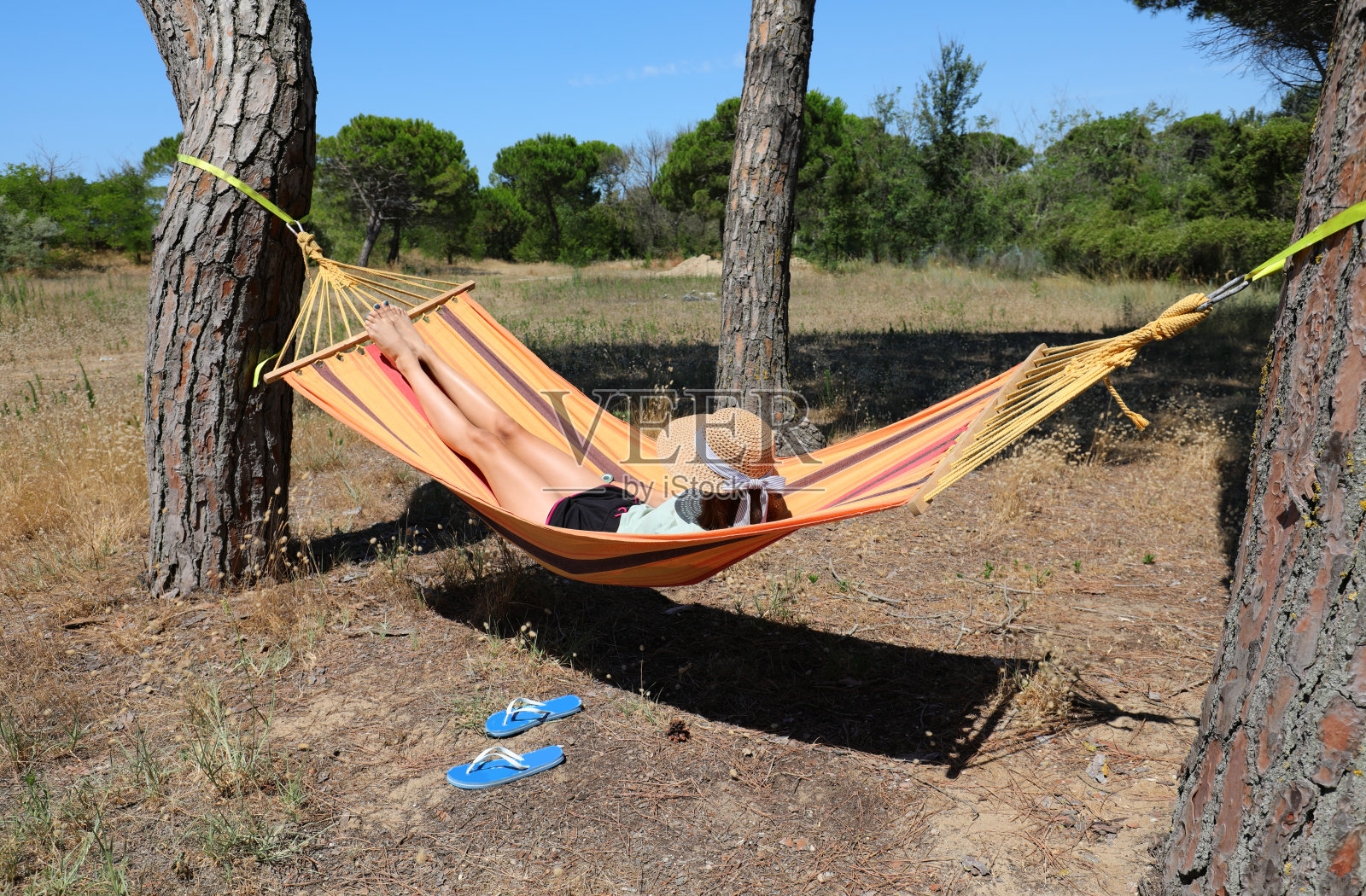 戴草帽的女孩在吊床上荡秋千照片摄影图片