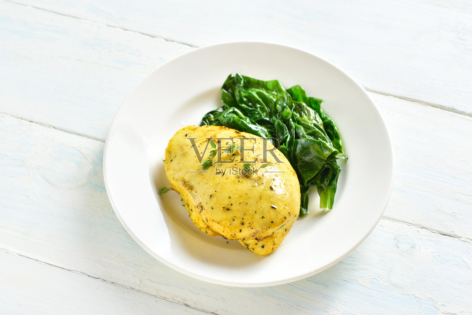 烤姜黄鸡胸肉和炒菠菜照片摄影图片