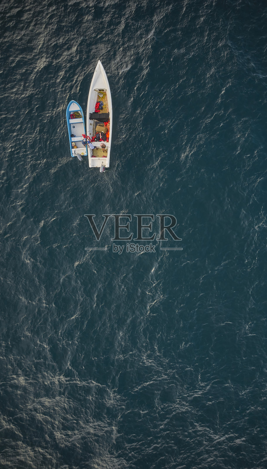 航拍的传统渔船在卡拉巴莱达与水晶清澈蓝绿色的海,拉瓜伊拉,委内瑞拉。照片摄影图片