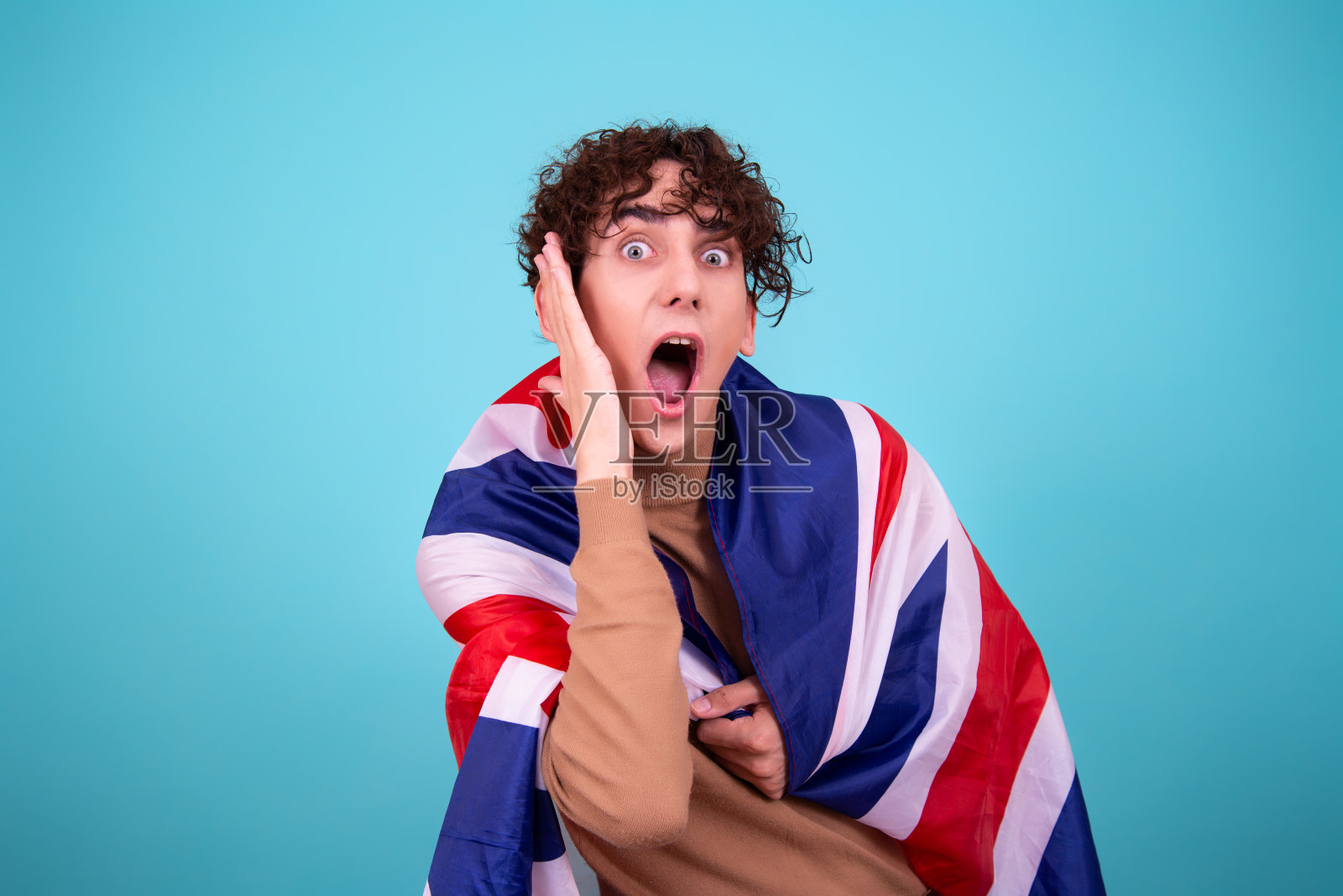 年轻有魅力的家伙在工作室摆着国旗。照片摄影图片