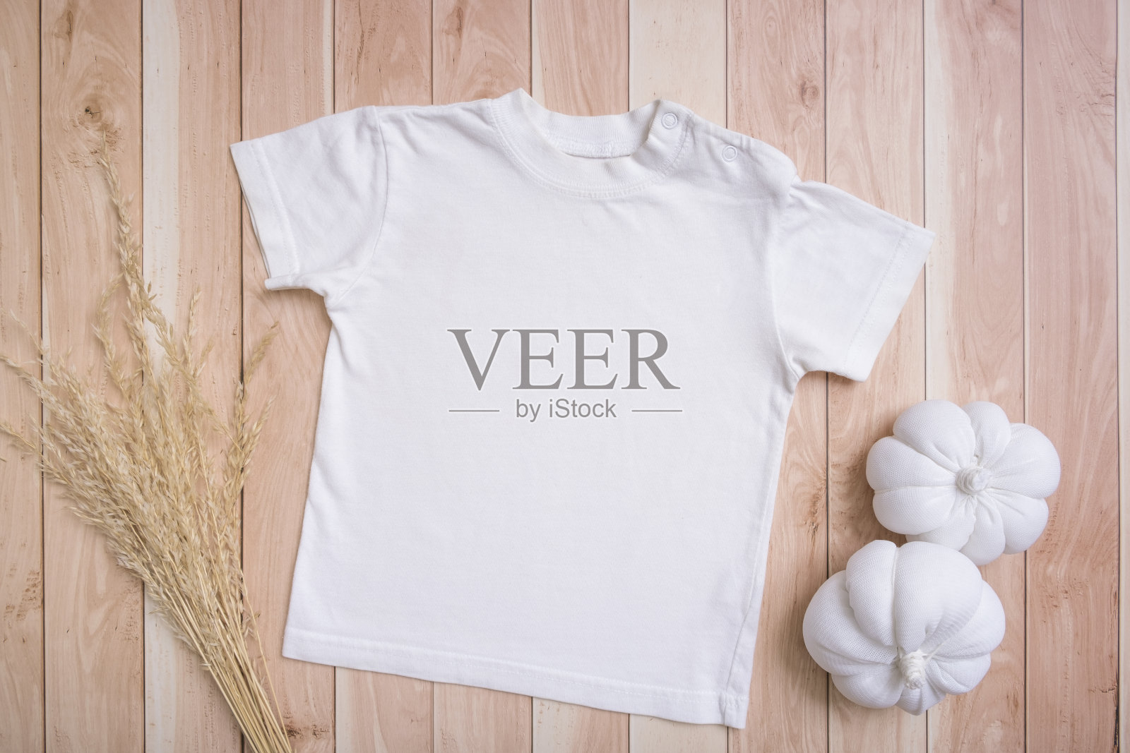 白色婴儿t恤俯视图。模型的标志,文字或设计的木制背景。用南瓜做成的儿童衣服照片摄影图片