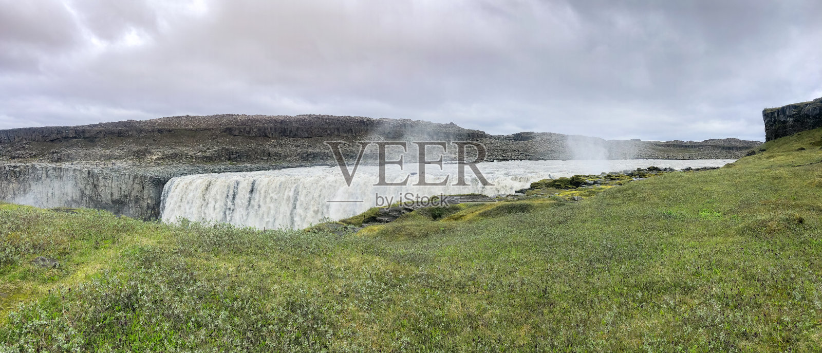 西侧Dettifoss瀑布全景从草和苔藓覆盖的夏季河岸照片摄影图片