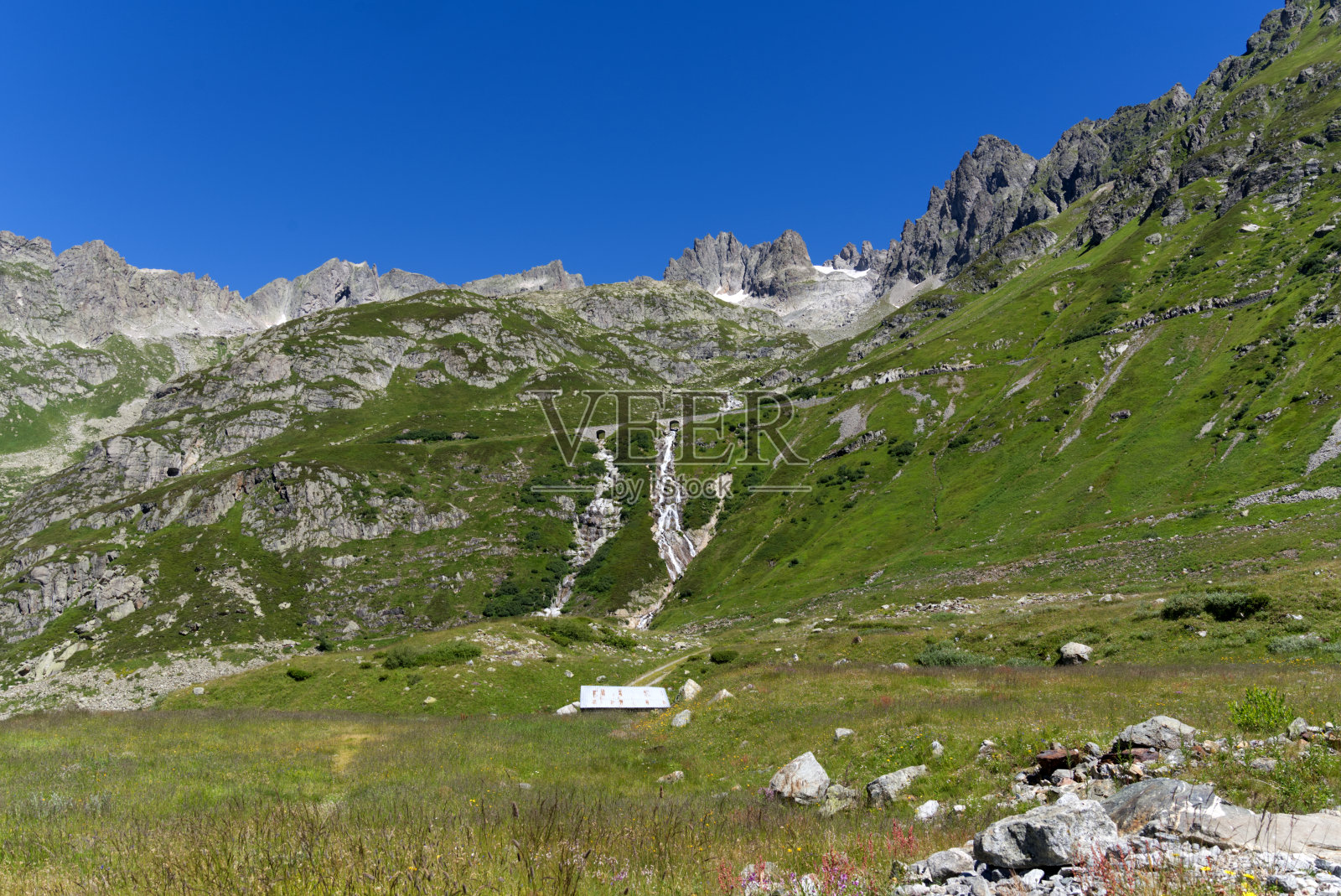 瑞士山口Sustenpass在一个阳光明媚的夏天,有道路,山景,河流和石桥。照片摄影图片