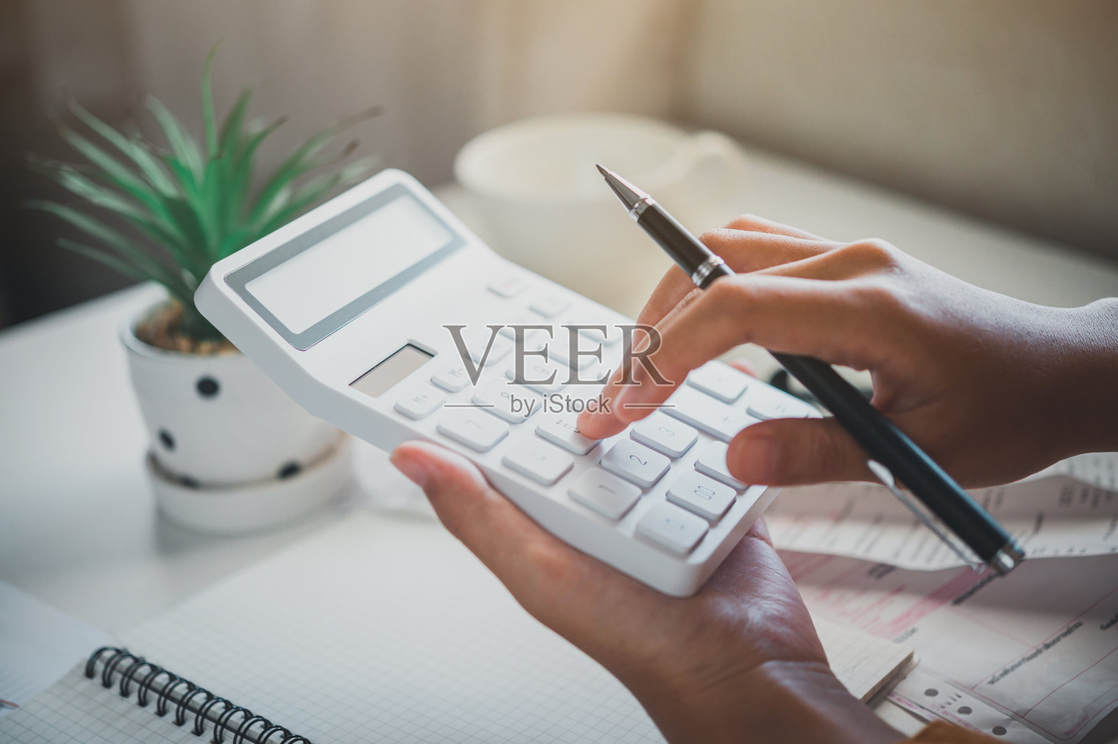 商务人员坐在办公室的办公桌前用计算器工作。经营理念分析与规划照片摄影图片