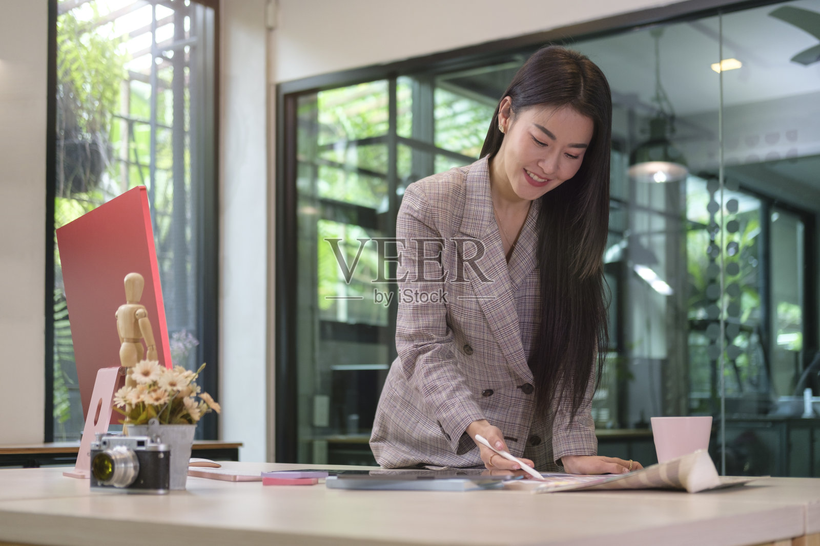 微笑的女性平面设计师工作在创意办公室的nee项目。照片摄影图片