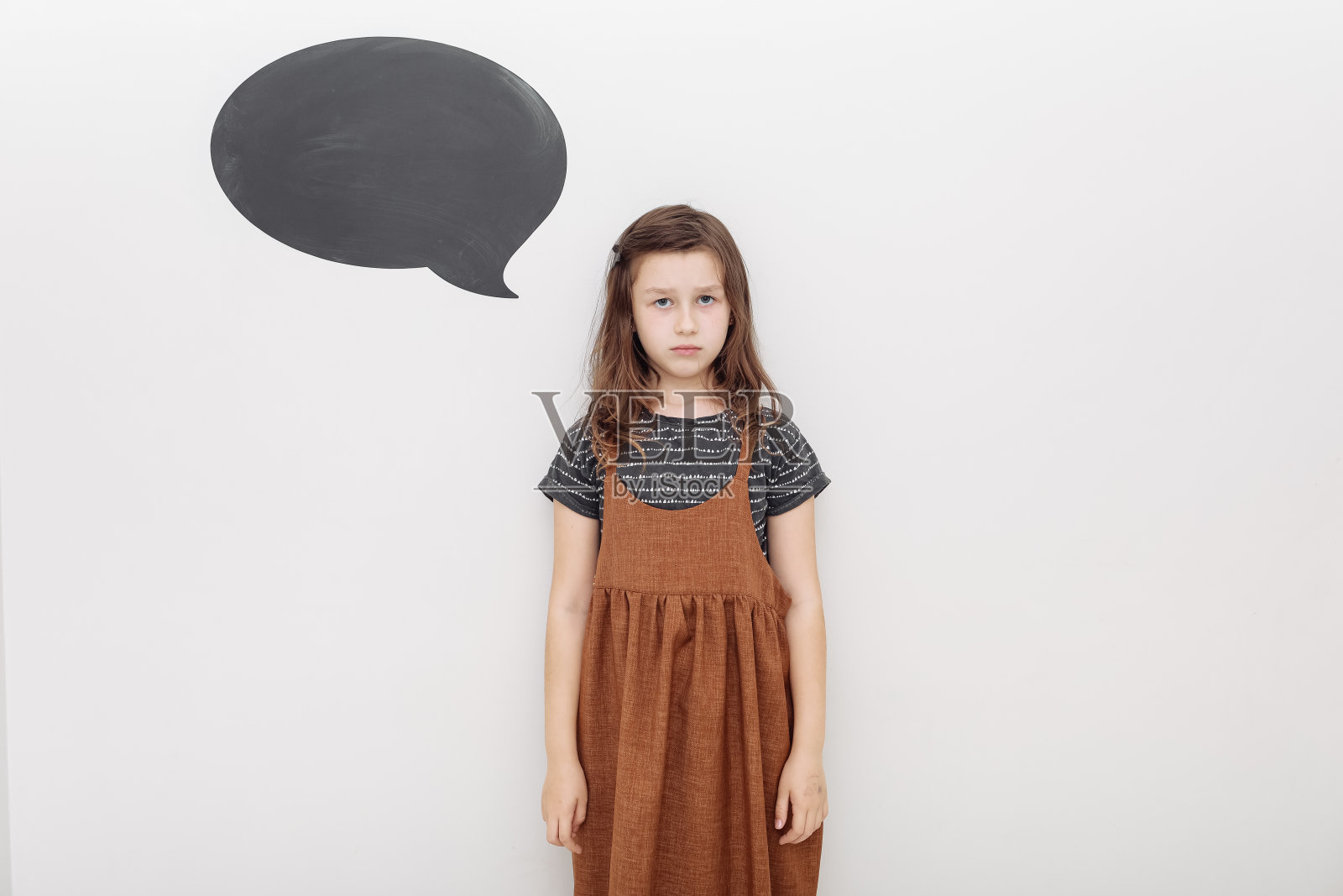 小孩儿翻着白墙沮丧又担心又苦恼,哭着又生气又害怕。悲伤的表情。模型在墙壁上照片摄影图片