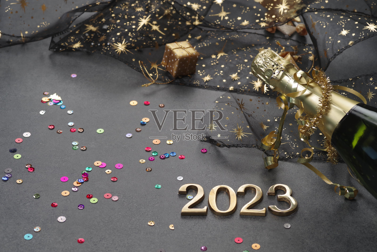 新年概念,明亮的灯光和香槟瓶,金色的散景背景照片摄影图片