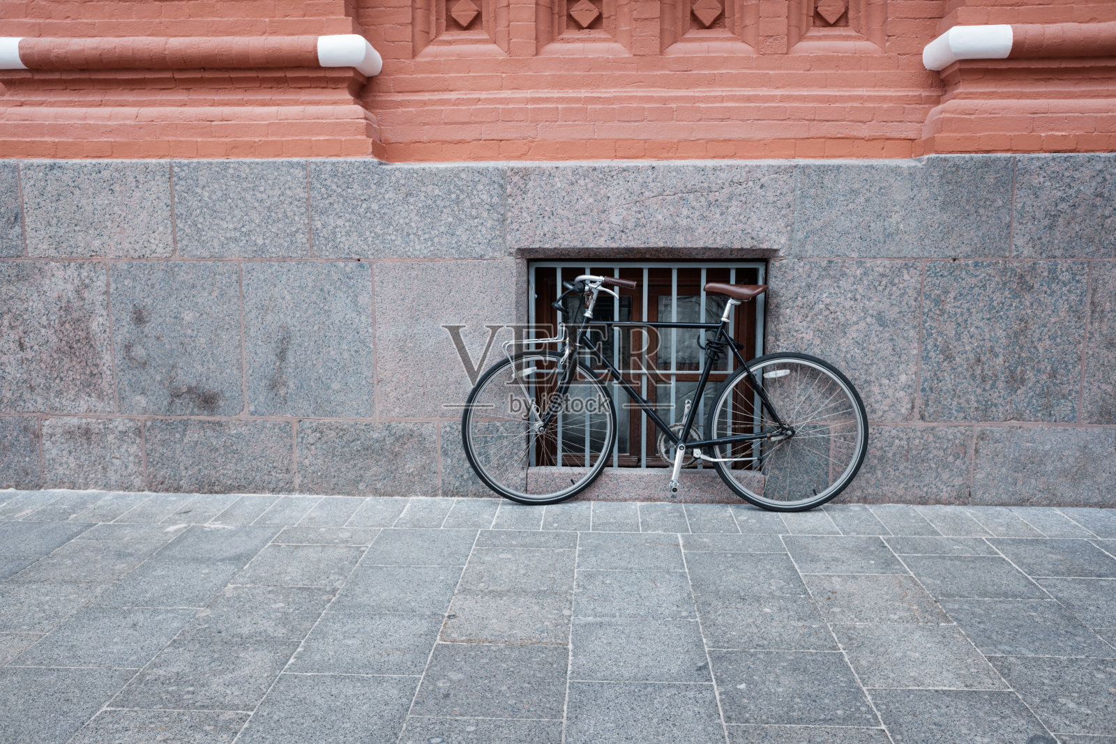街边石墙旁的古董自行车照片摄影图片