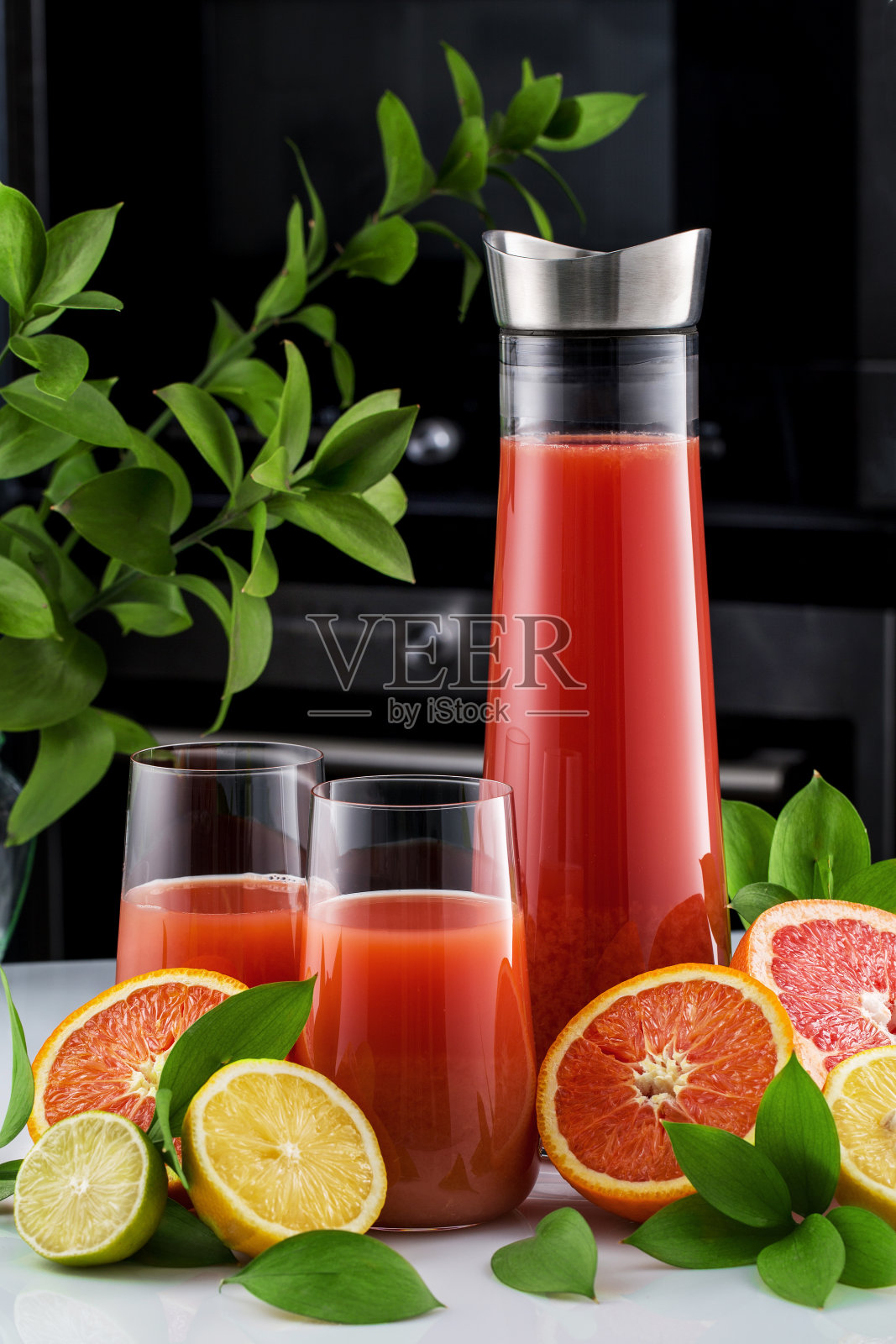 新鲜的葡萄柚,玻璃杯和一壶葡萄柚汁。特写镜头。照片摄影图片