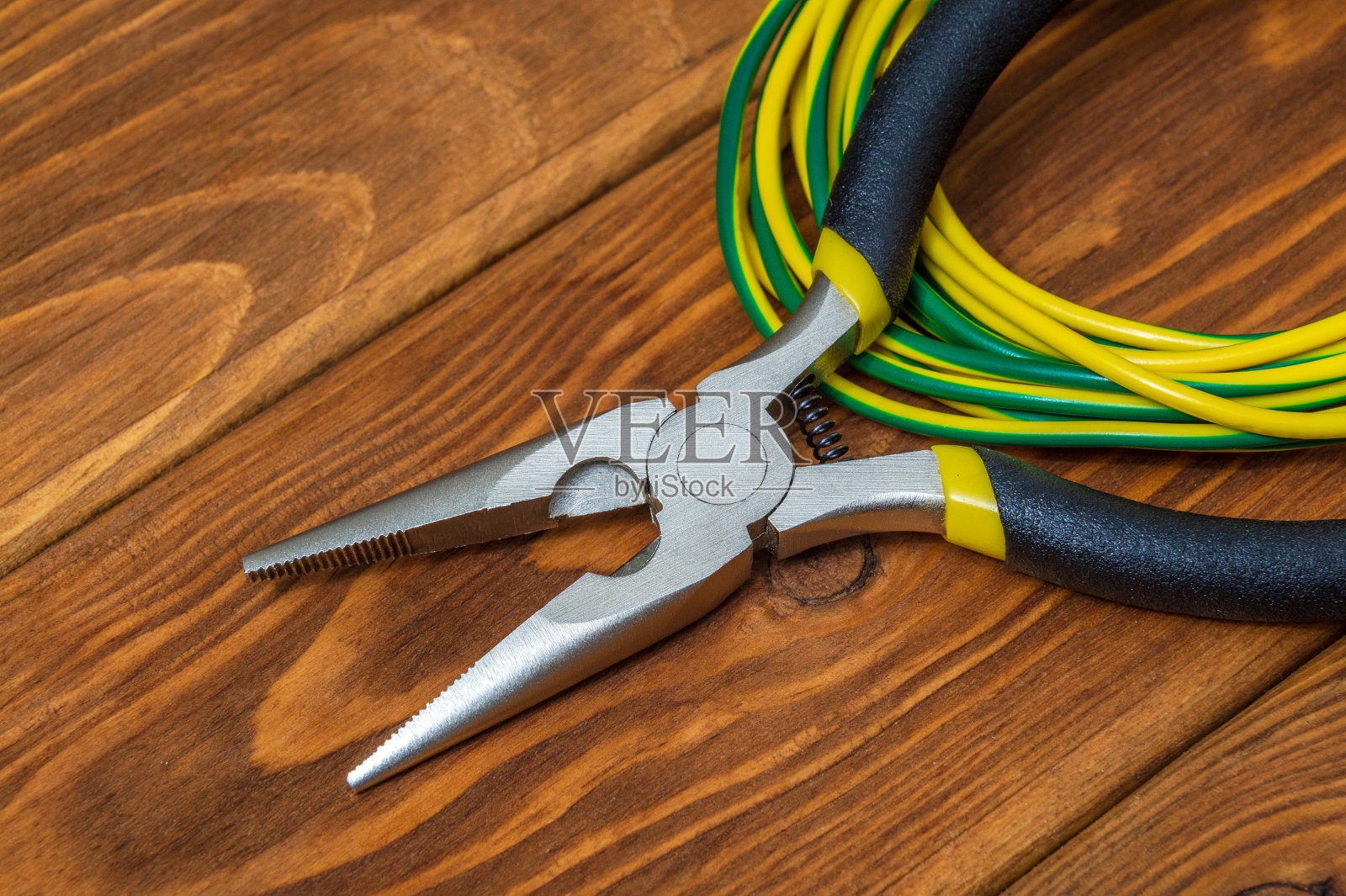 用于修理通电系统或通信设备的老式木板上的电工钳和电线照片摄影图片