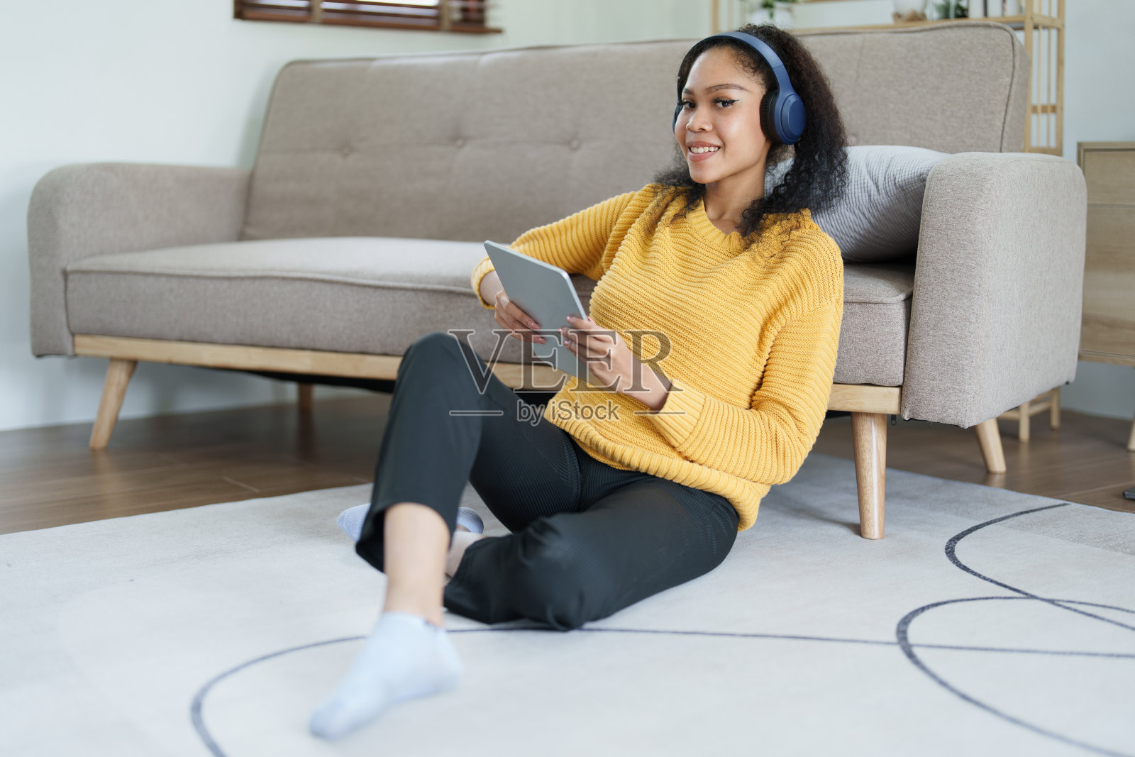 戴着耳机用平板电脑的非裔美国人笑得很开心照片摄影图片