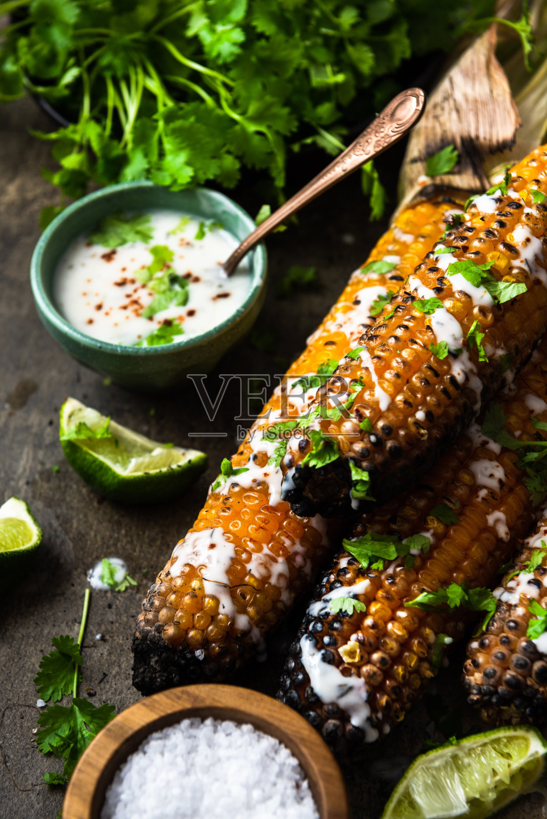 烤玉米棒,配上啤酒、盐、香菜和酸橙照片摄影图片