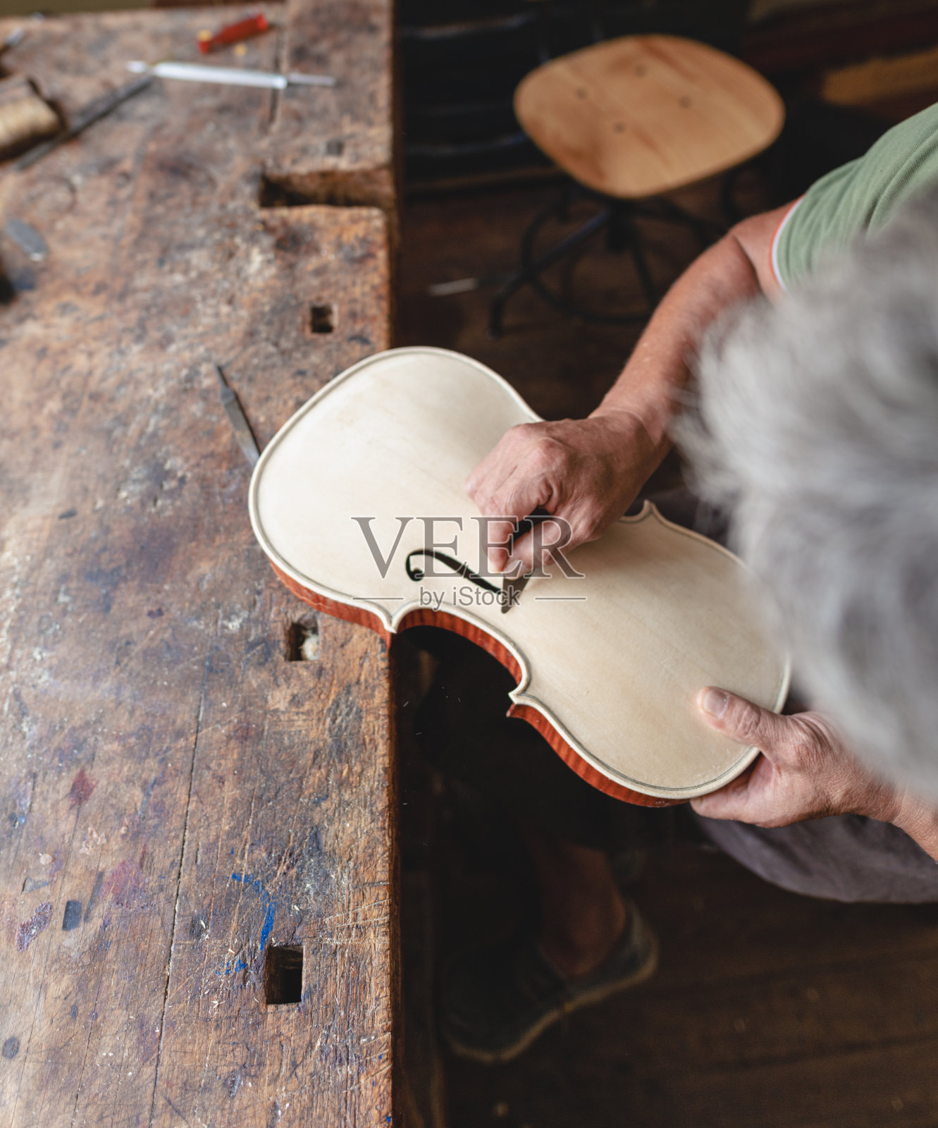琴师用刀雕刻和雕刻小提琴的f孔照片摄影图片
