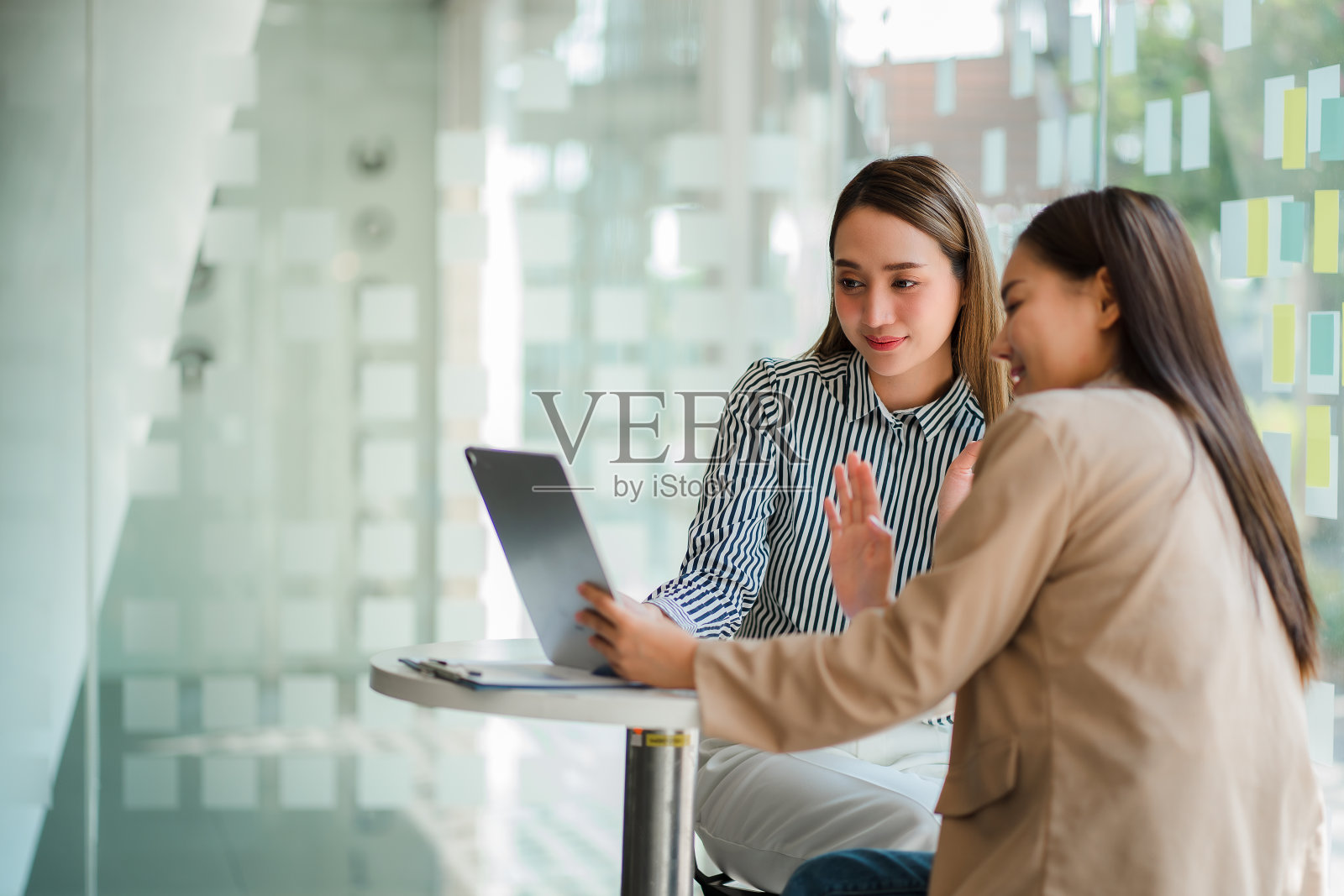 两位亚洲商业女性在办公室讨论营销策略工作坊概念。照片摄影图片