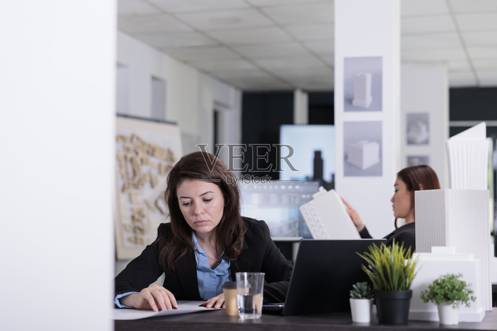 Cad设计师在联合办公空间中处理项目蓝图照片摄影图片