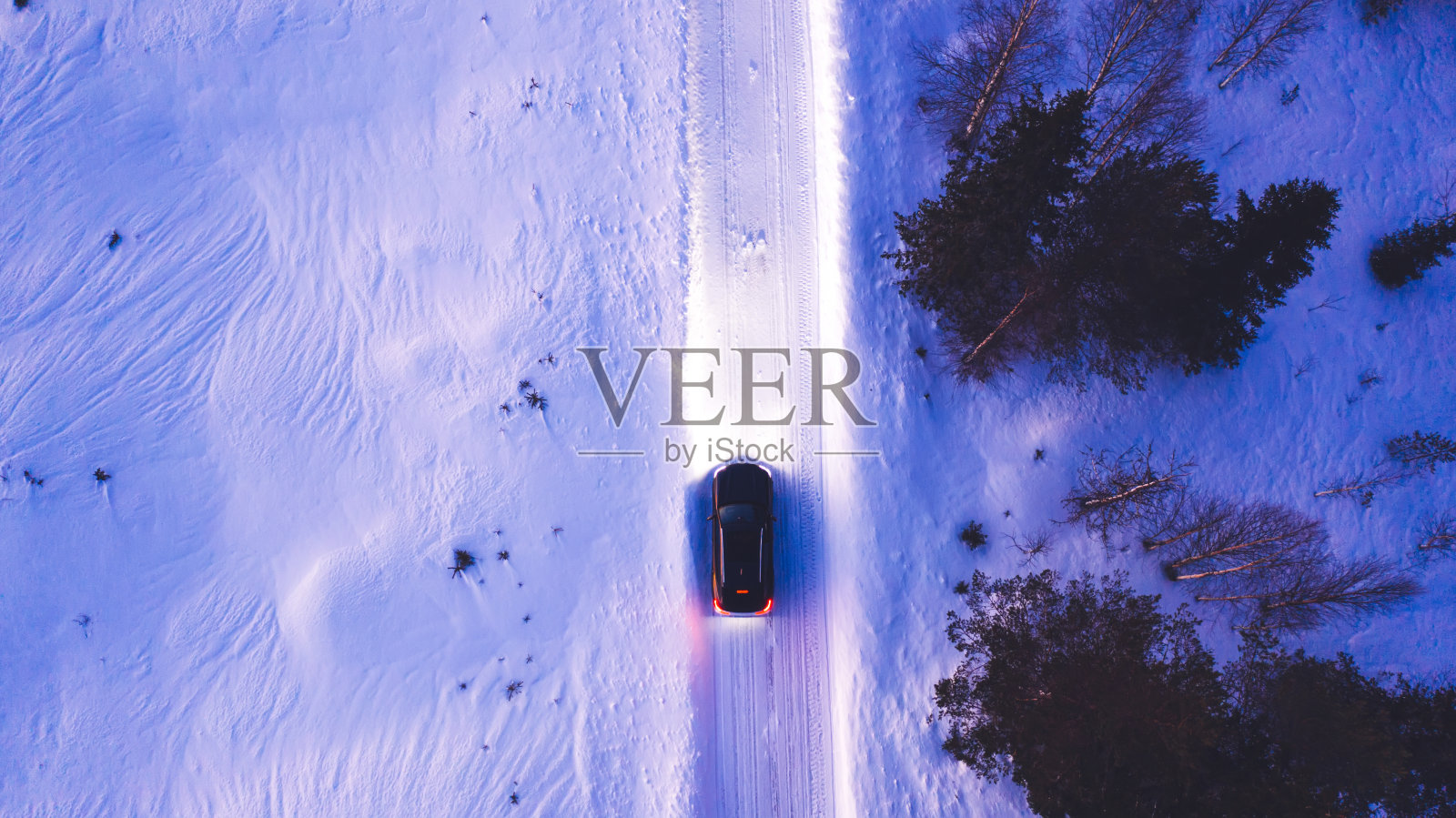 黑色汽车在乡村冬季道路上行驶的鸟瞰图,车灯照亮了道路,suv汽车穿越雪域的鸟瞰图照片摄影图片