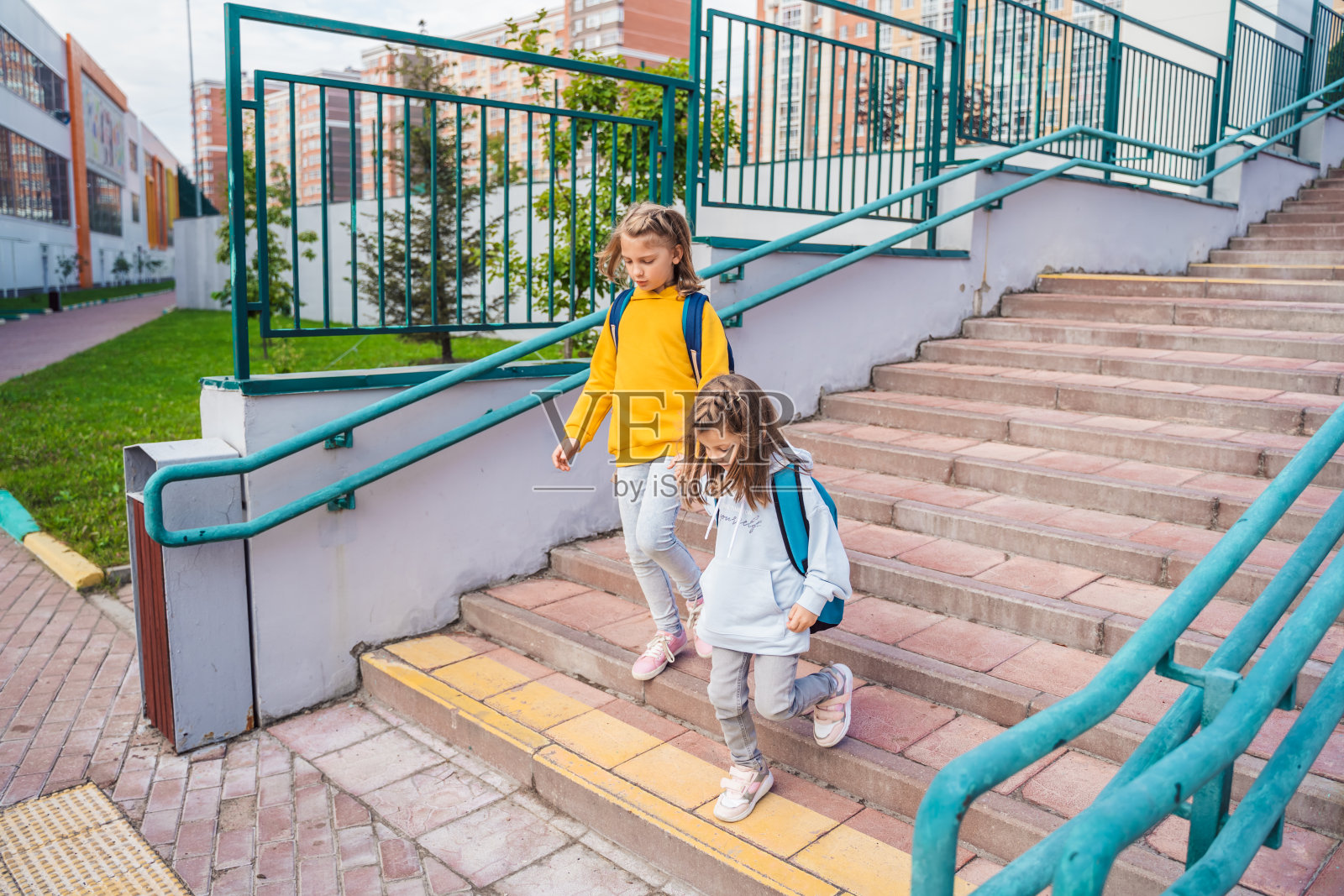 回到小学,小学。小女孩们,背着大书包的姐妹们匆忙赶路,在秋天的早晨独自去上一年级。教育,孩子的未来。快乐的,不快乐的学生,楼梯上的孩子照片摄影图片