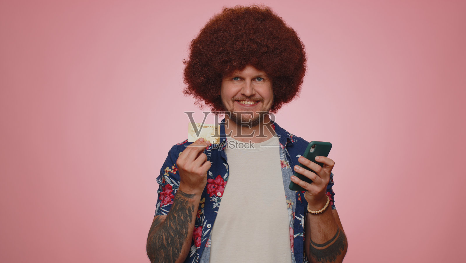 一名年轻男子一边用信用卡和智能手机转账,一边在网上购物照片摄影图片