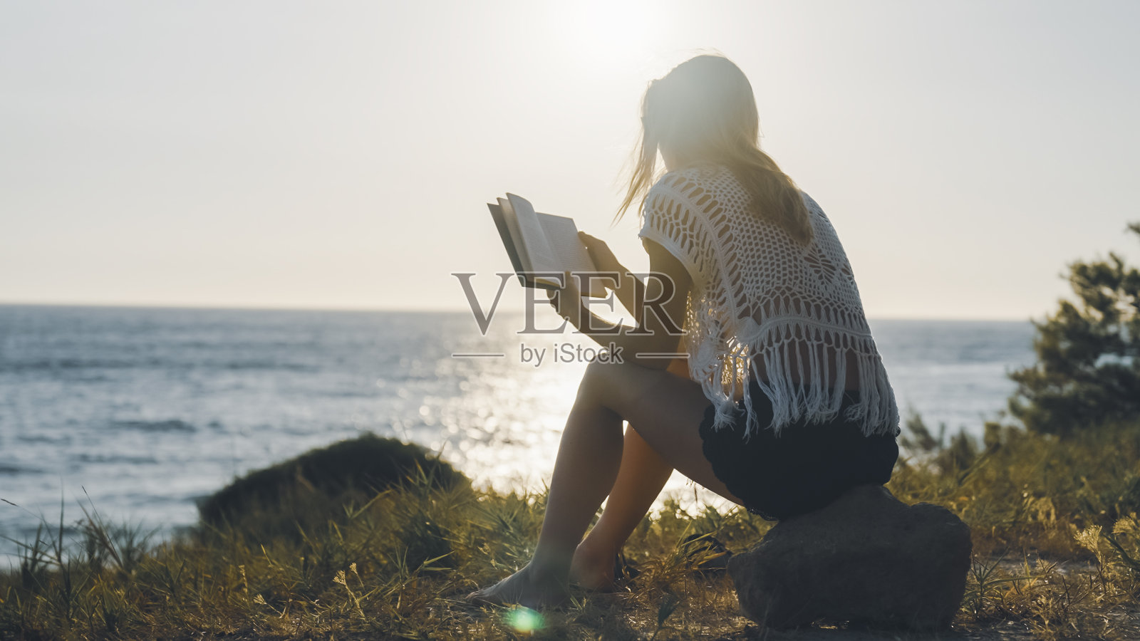 女人在夕阳西下的时候看书照片摄影图片