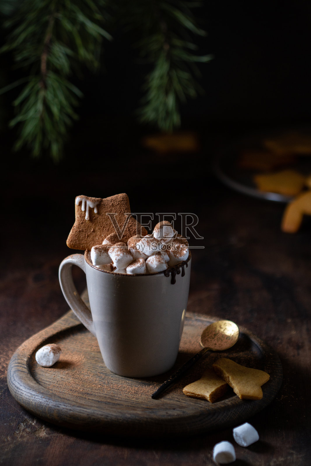 热巧克力杯装饰着棉花糖和星形姜饼放在桌上照片摄影图片