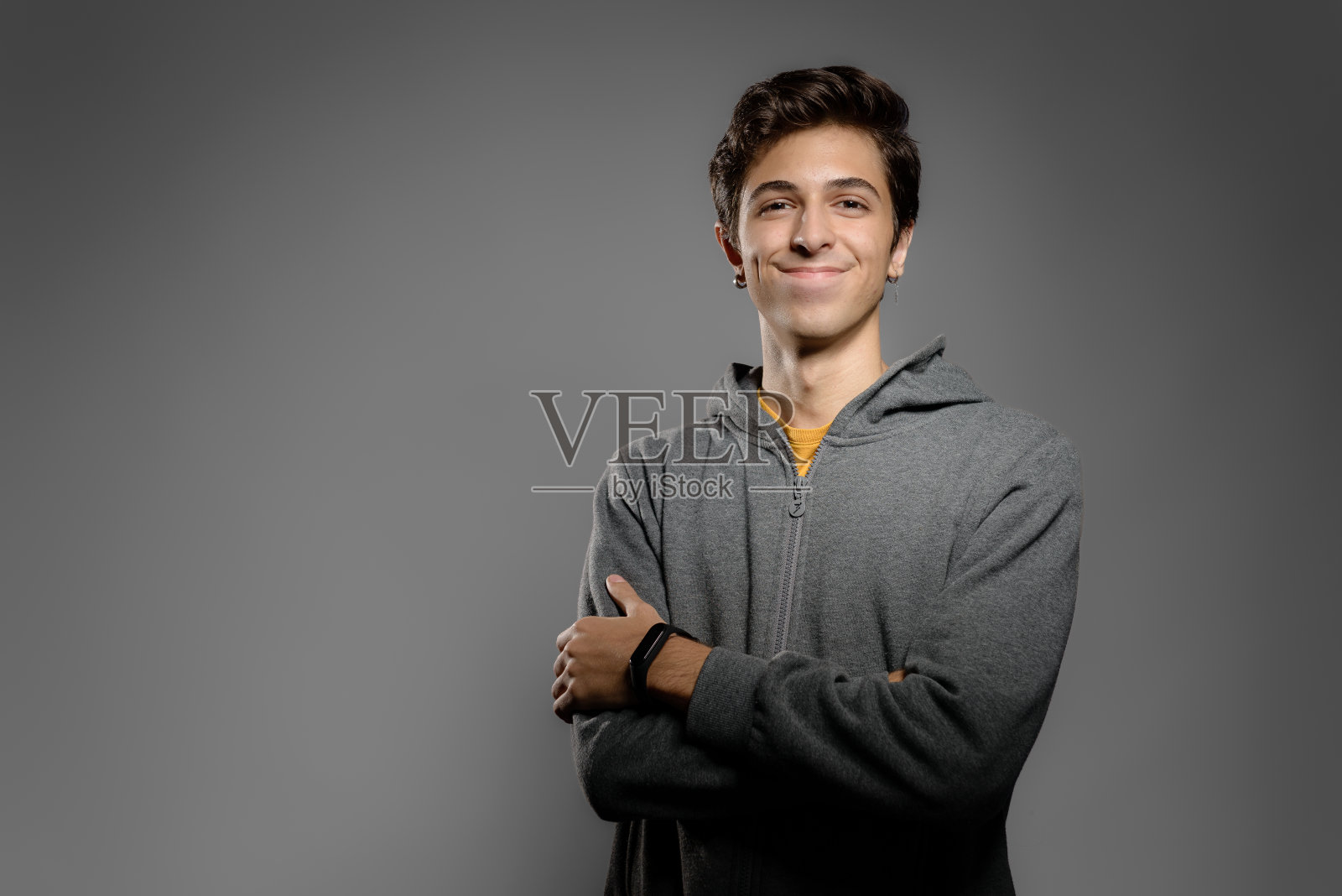 年轻的学生双臂交叉看着相机的肖像照片摄影图片