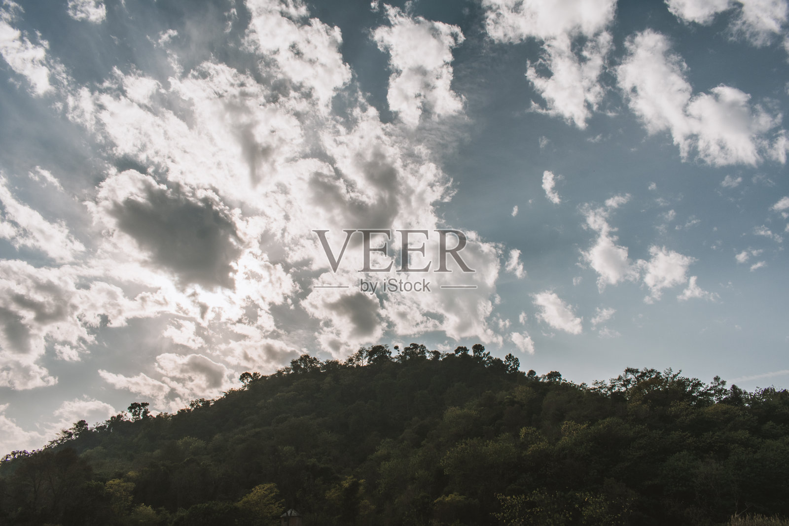 太阳在白云后面,蓝天在山上照片摄影图片