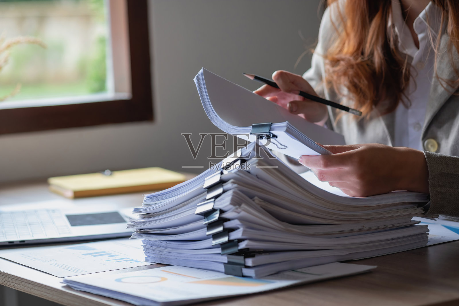 市场营销、财务、会计、计划、商业女性用图表统计分析公司的结果和利润。使用笔记本电脑和计算器来计算公司的结余。照片摄影图片