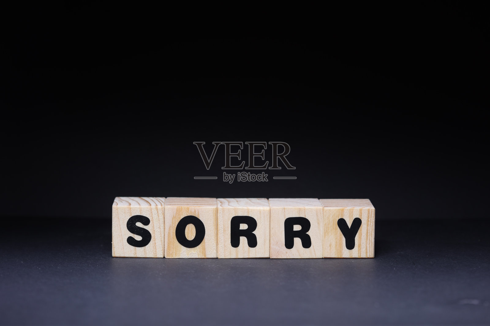 对不起,在黑色背景上的木头方块照片摄影图片