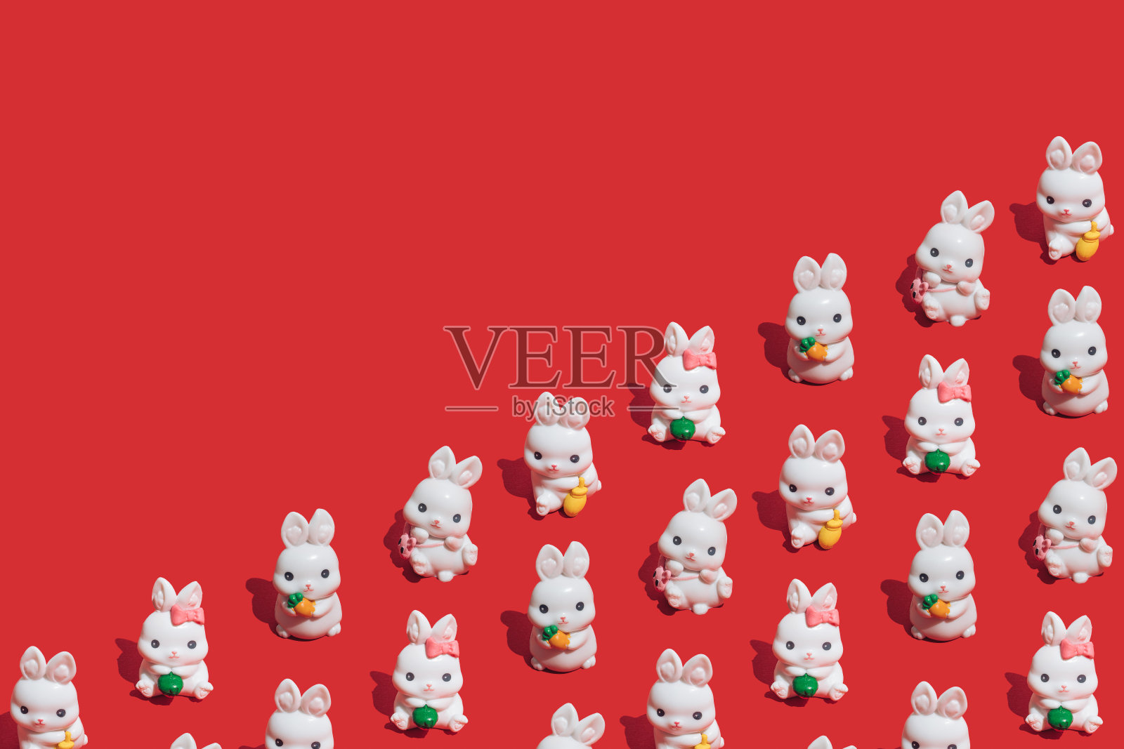 无缝模式的小白兔在充满活力的红色背景。兔是中国新年的象征。2023年快乐,好运!照片摄影图片