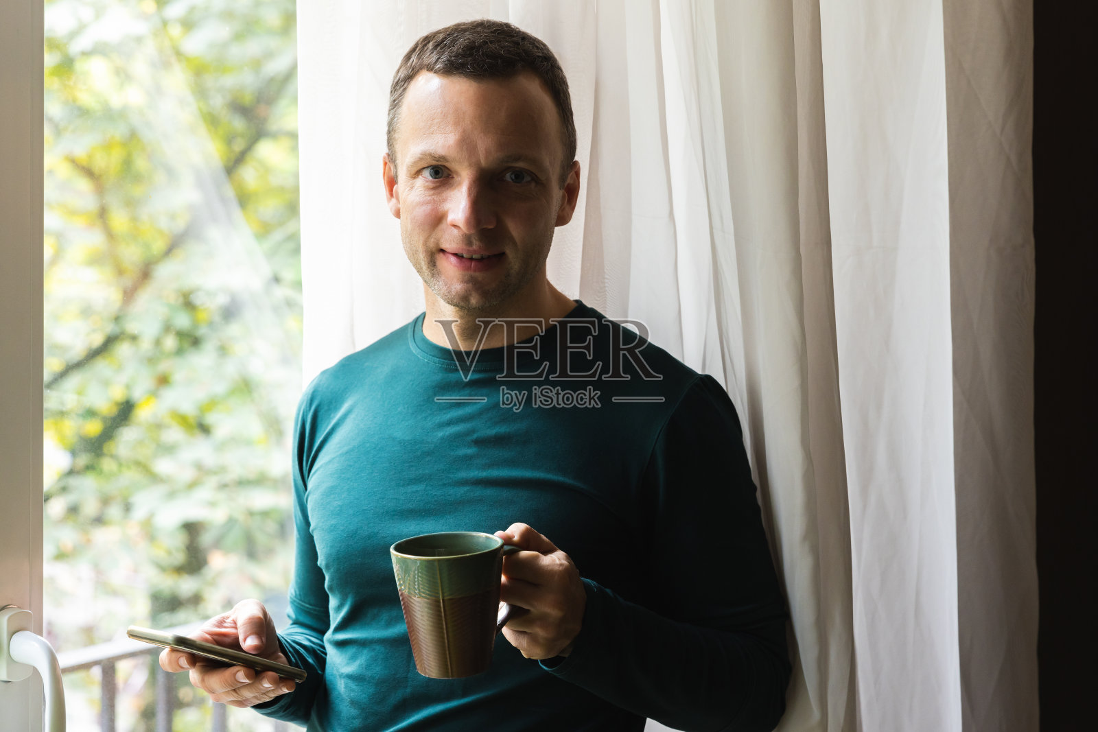 手拿咖啡和智能手机的男人照片摄影图片