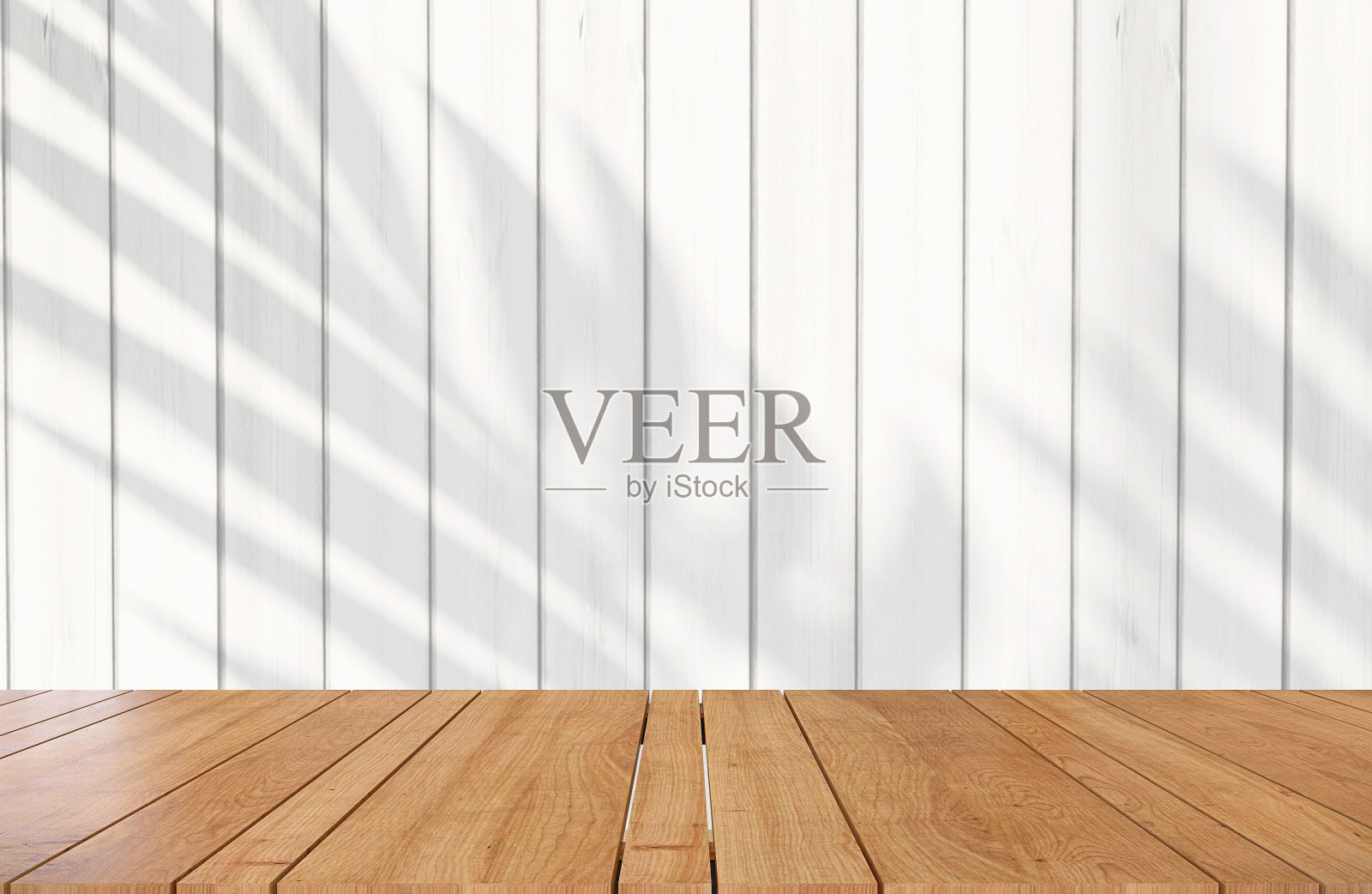 木制桌面或台面与白色木栅栏和阴影的怪兽叶植物在户外阳光的背景照片摄影图片