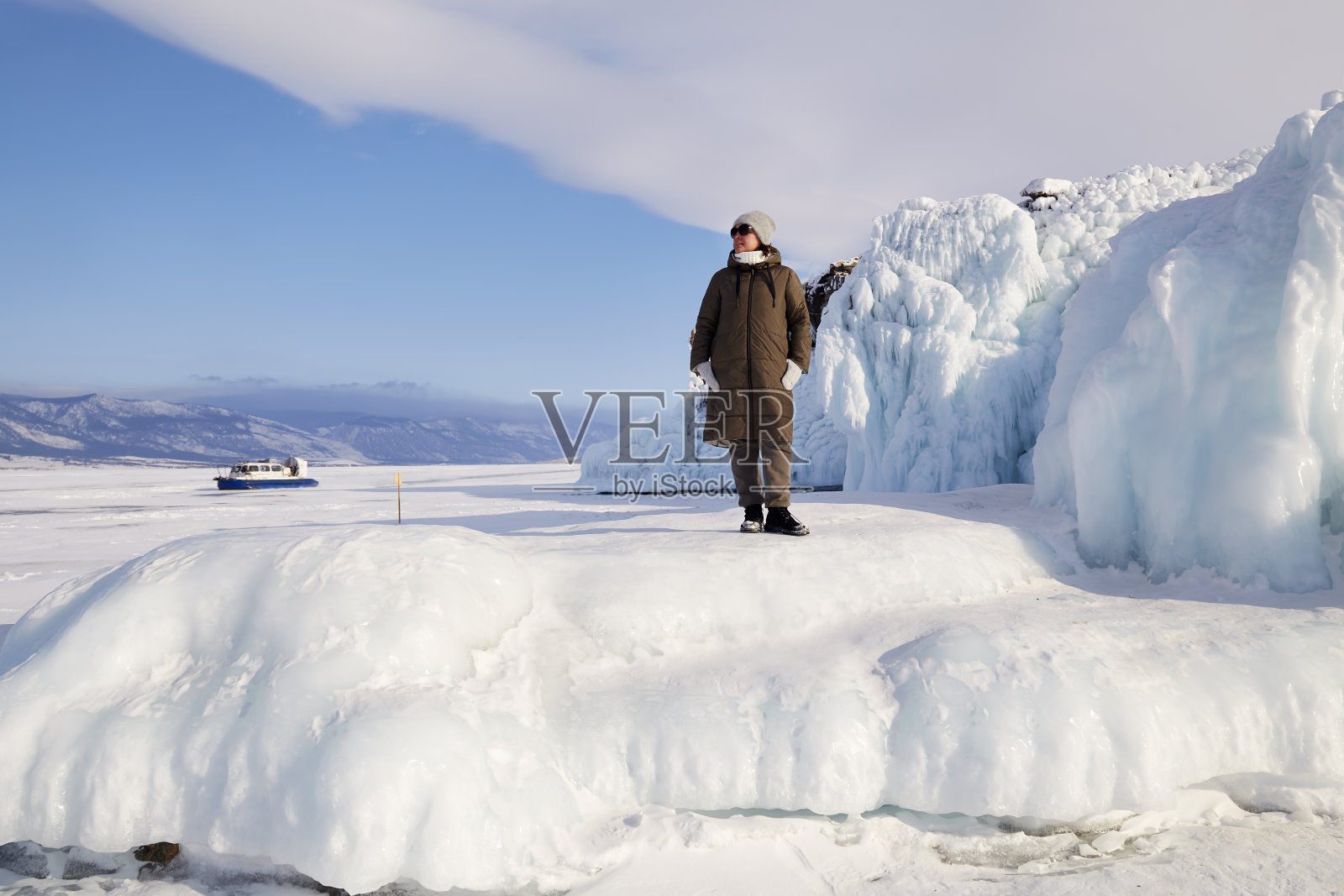 一个女人在欣赏美丽的冬季风景。照片摄影图片