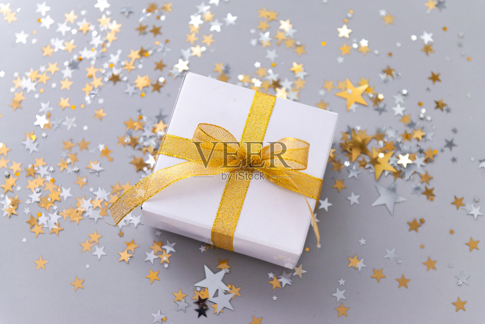 新年的装饰金黄色的五彩纸屑和礼品盒在米色的背景照片摄影图片