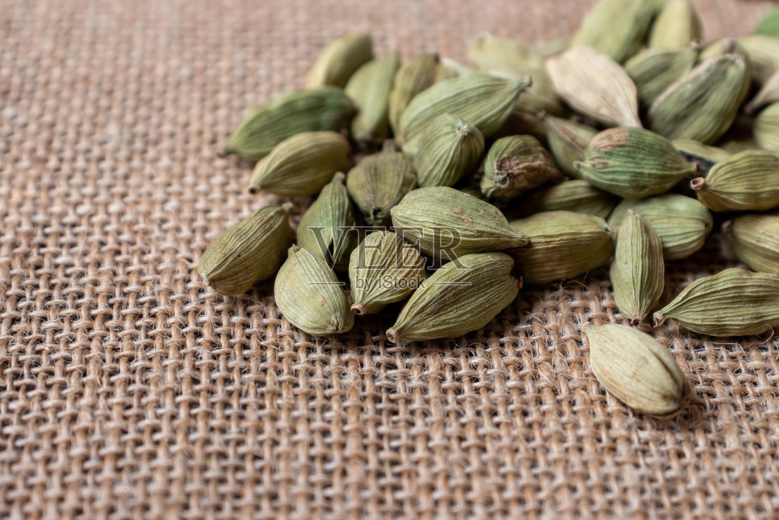 水平方向分离在粗麻布上的小豆蔻荚或小豆蔻的特写,调味品和香料照片摄影图片