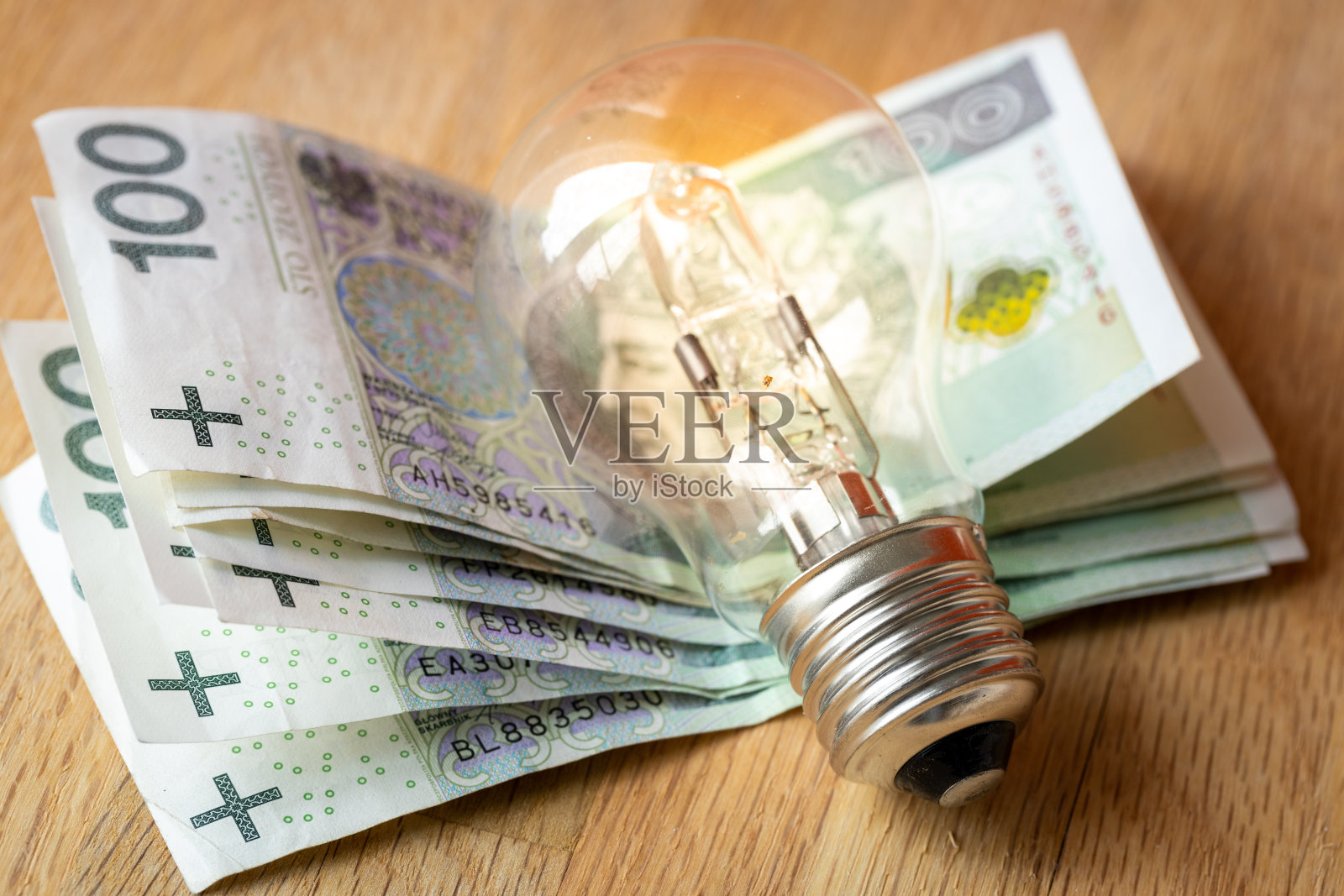 波兰货币几百波兰兹罗提和一个灯泡,提高波兰能源和电力价格的概念照片摄影图片