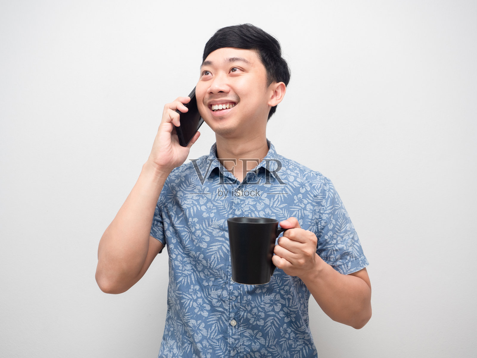 快乐的男人拿着咖啡杯,用手机交谈,人像照片摄影图片