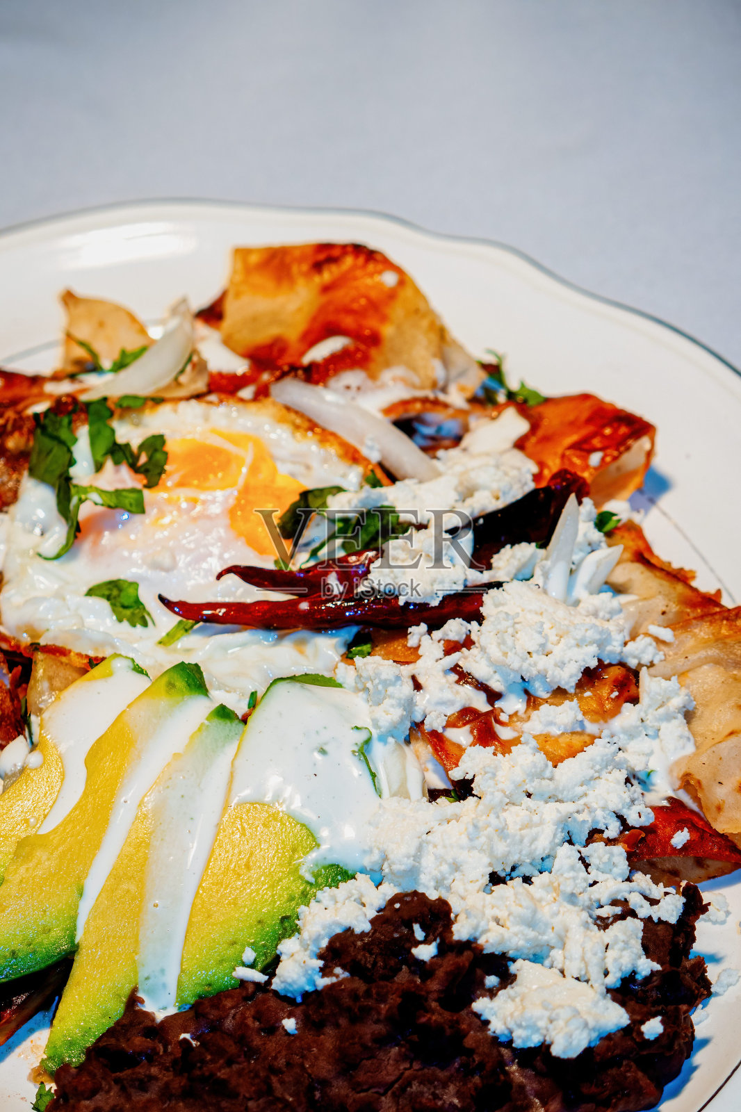 奇拉奎斯(chilaques)是一种用红酱、奶酪、奶油和红辣椒做背景的墨西哥食物照片摄影图片