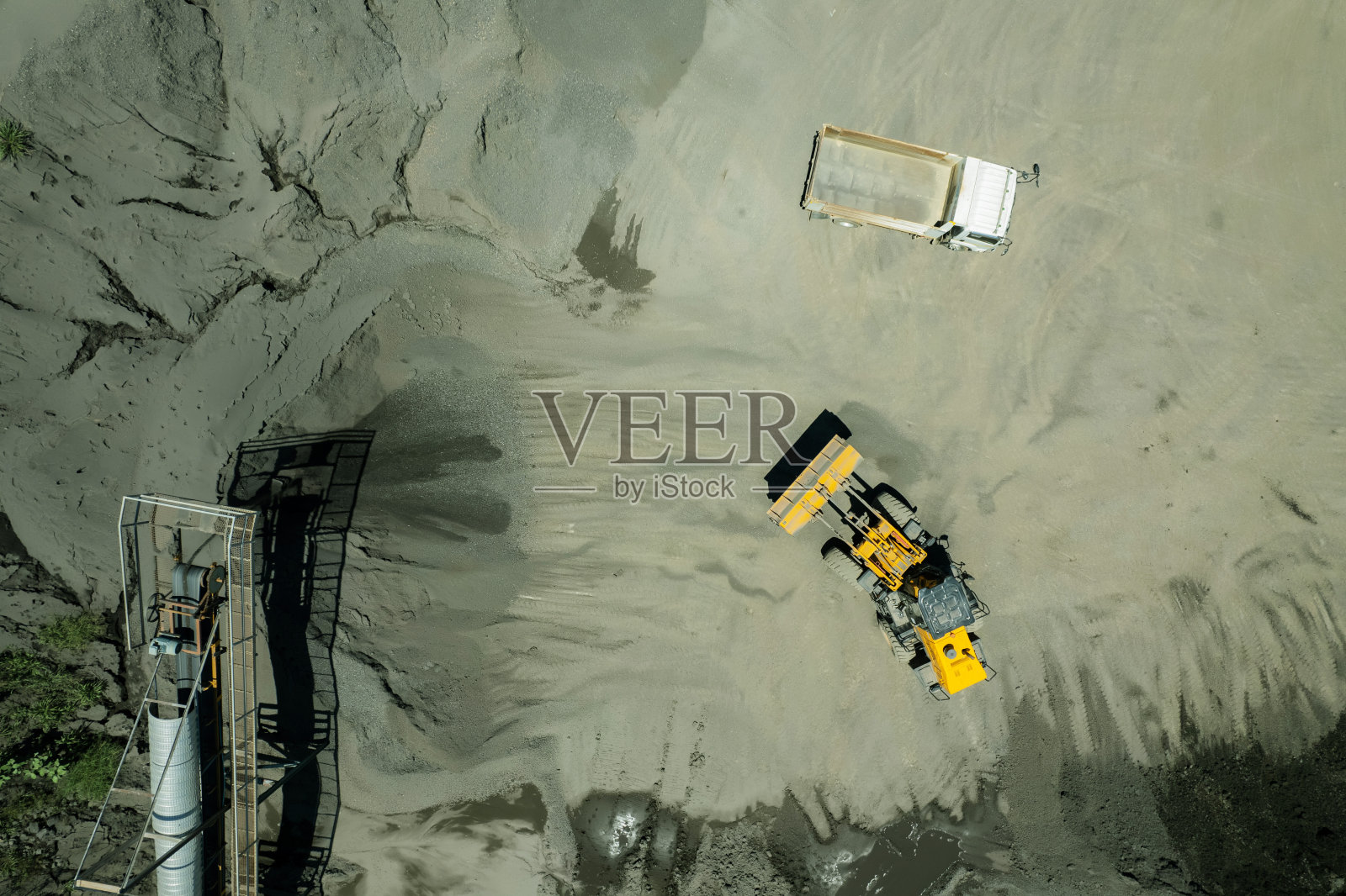 装沙工正在把石头铲进自卸卡车。照片摄影图片