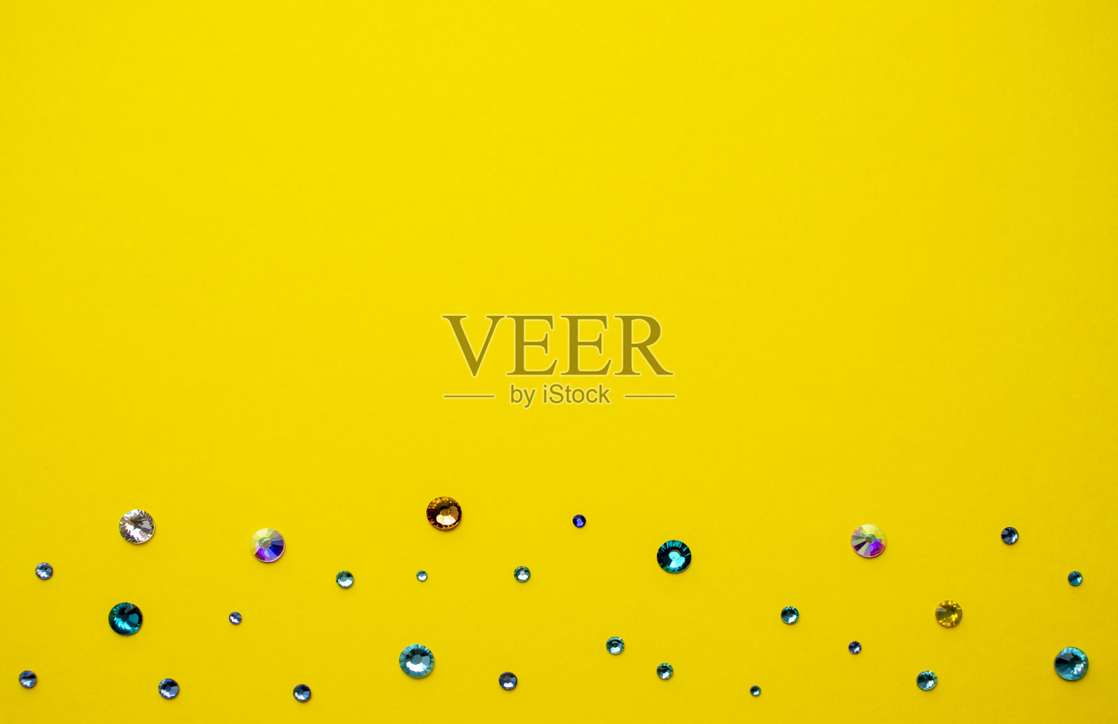 黄色背景上的彩色水钻,顶部照片。设计文本。照片摄影图片