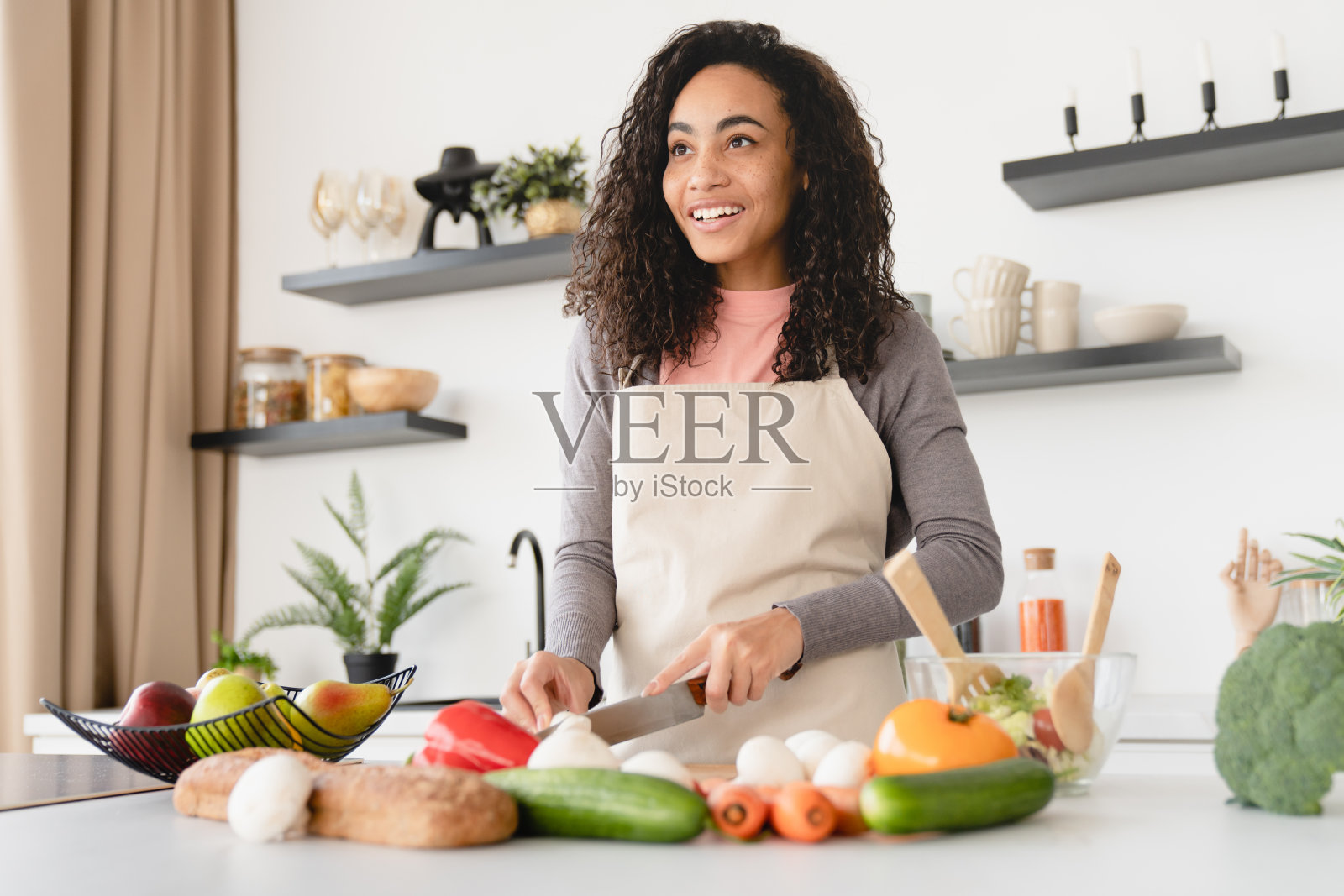 汤沙拉食谱。快乐的年轻非洲厨师,家庭主妇,做饭,准备食物,在家里的厨房,午餐,切蔬菜沙拉。纯素素食概念照片摄影图片