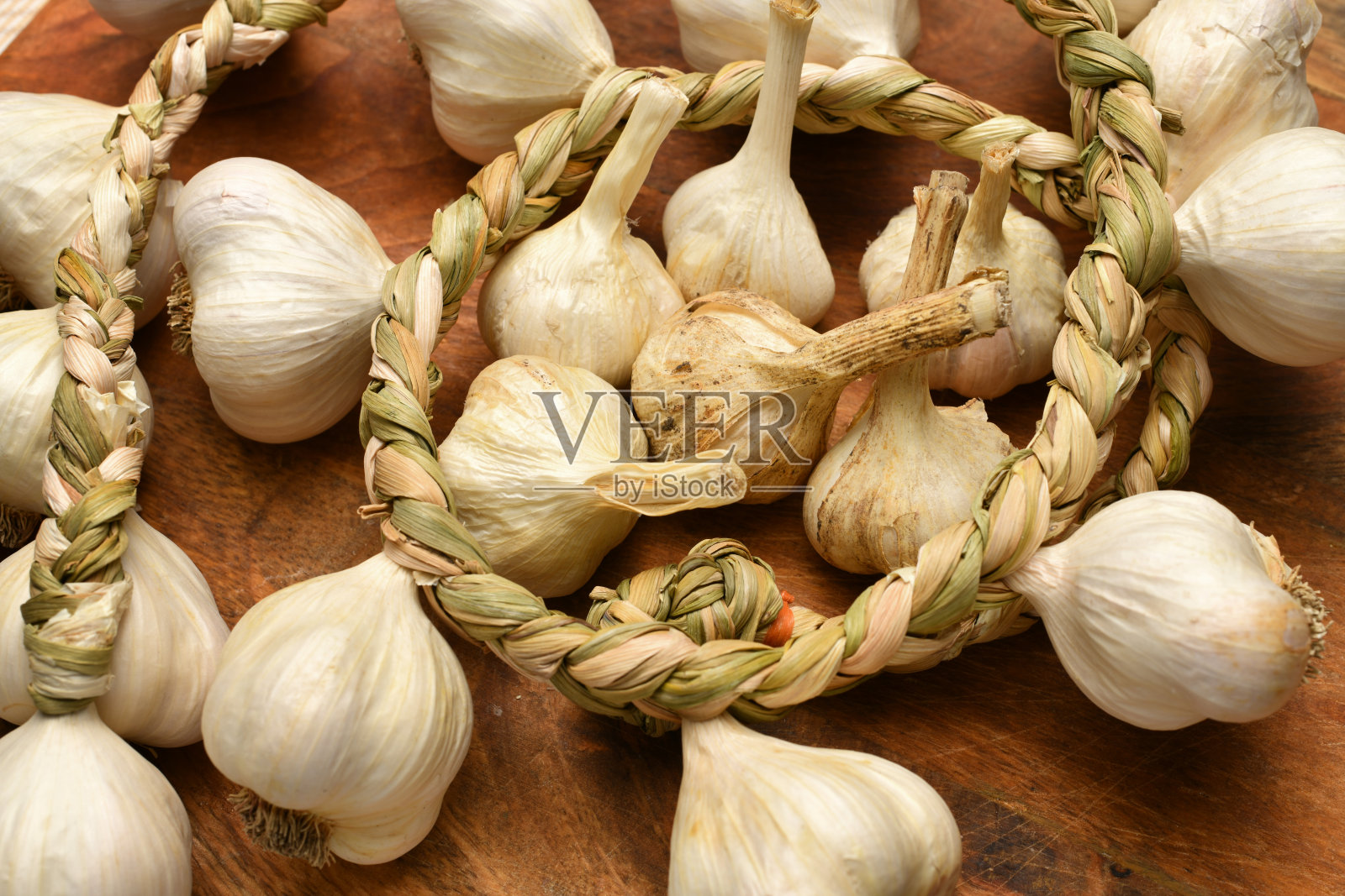 把蒜头和丁香编在质朴的木制背景上,美味又健康照片摄影图片