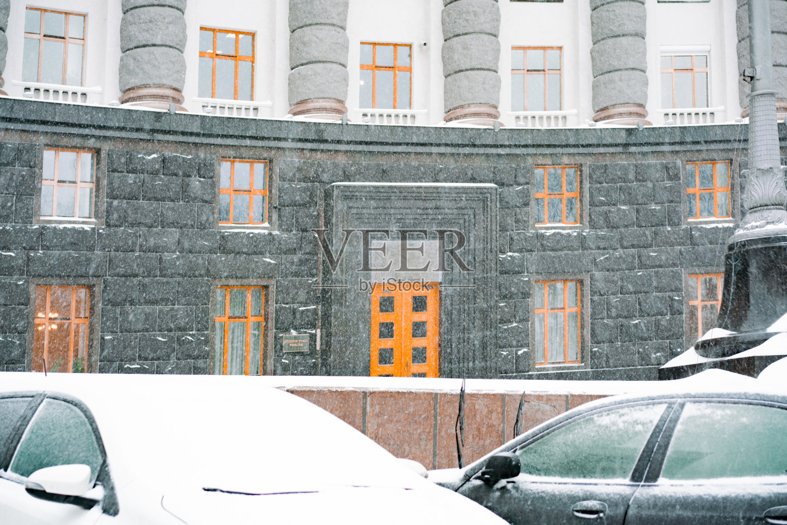 在一个下雪天,两辆被雪覆盖的汽车停在大楼附近。覆盖。下雪的。深。问题。很多。人行道上。城市。环境。旅行。寒冷的温度。重。基础设施。静止的照片摄影图片