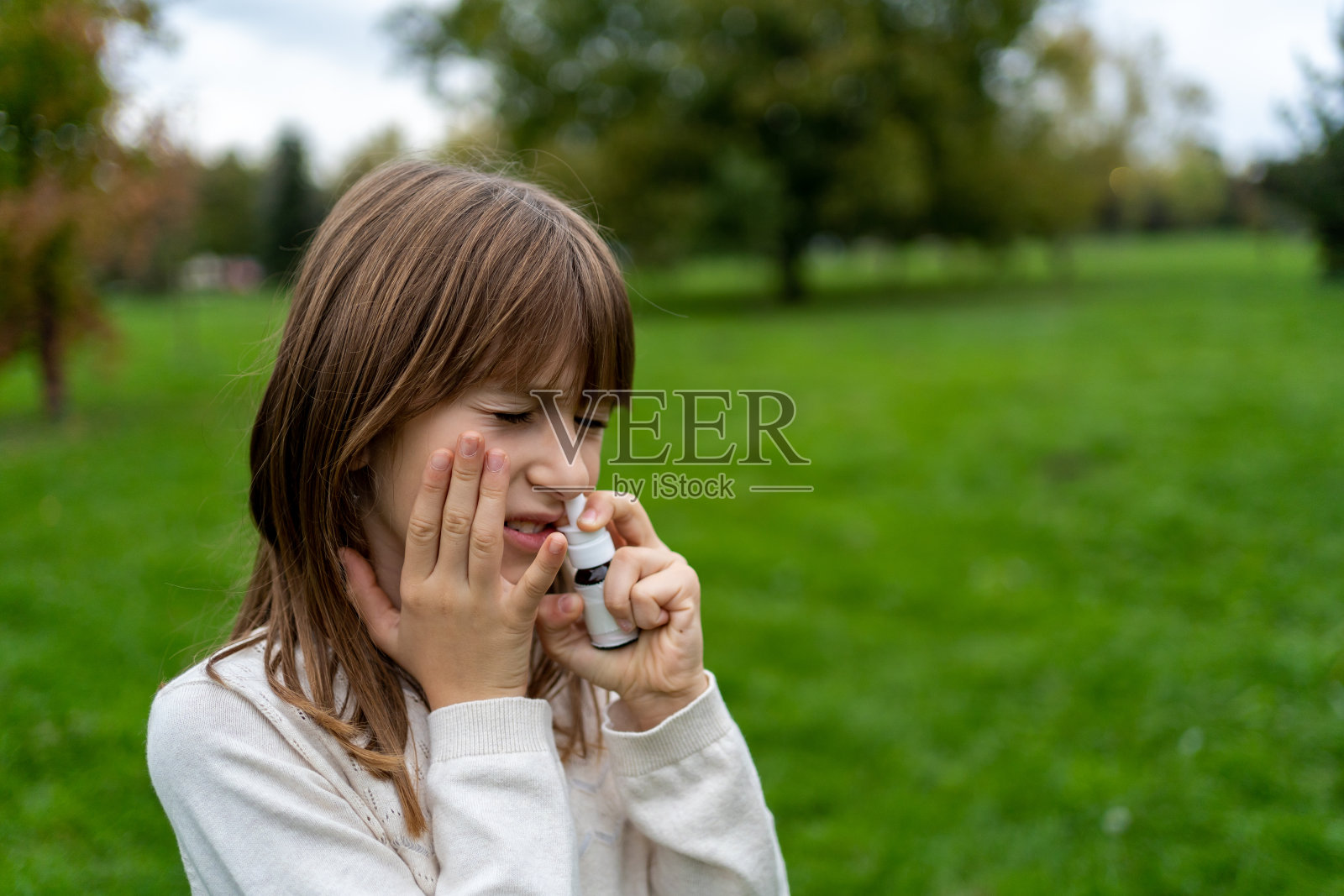 小女孩在大自然中有鼻窦炎问题照片摄影图片