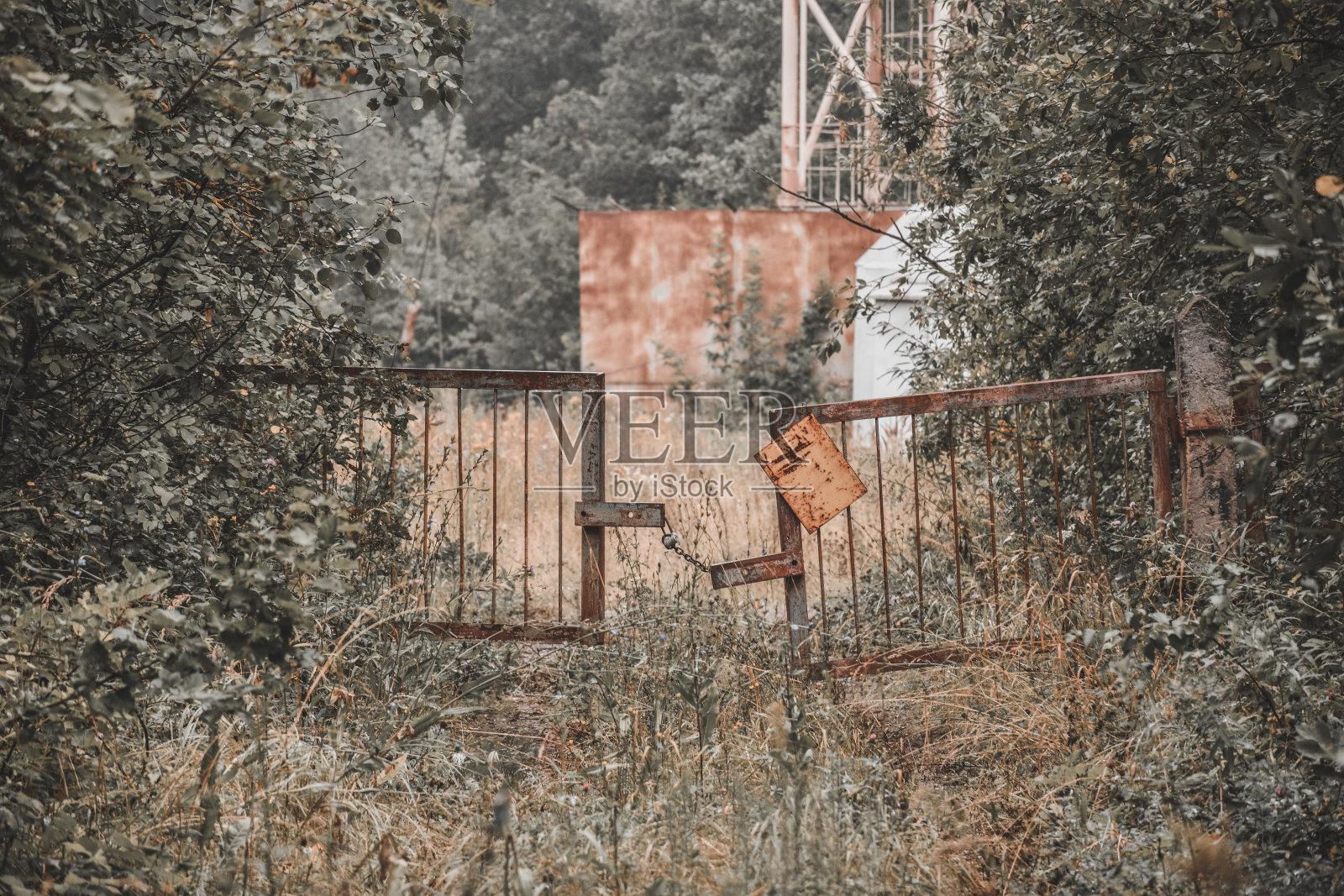 废弃建筑物的金属门上锁着生锈的铁链照片摄影图片